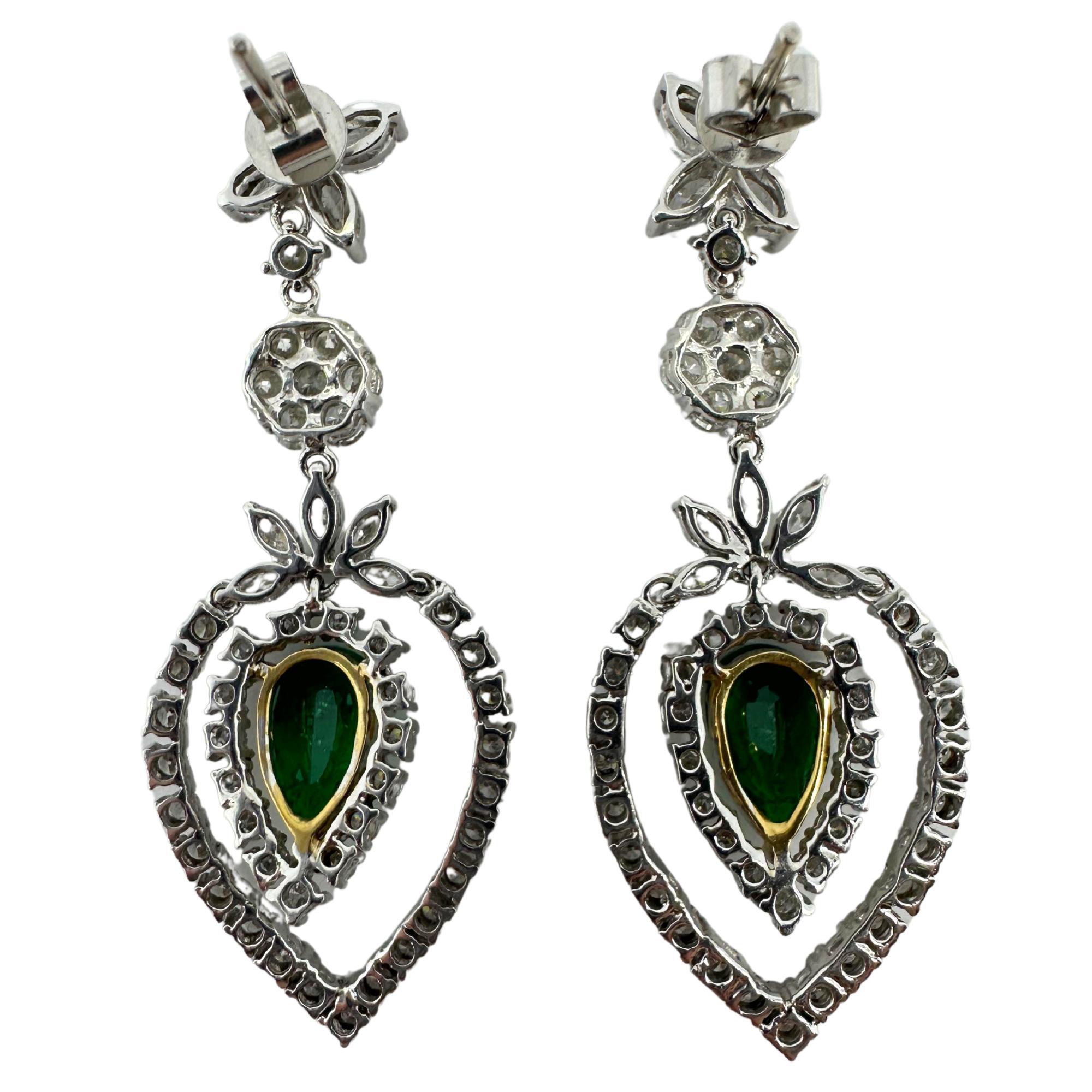 Ces remarquables boucles d'oreilles bicolores 18 carats présentent 2,12 carats d'émeraudes taille poire, élégamment encadrées par 1,47 carats de diamants taille marquise et 2,38 carats d'accents diamantés. Fabriqués en or blanc et jaune, ils