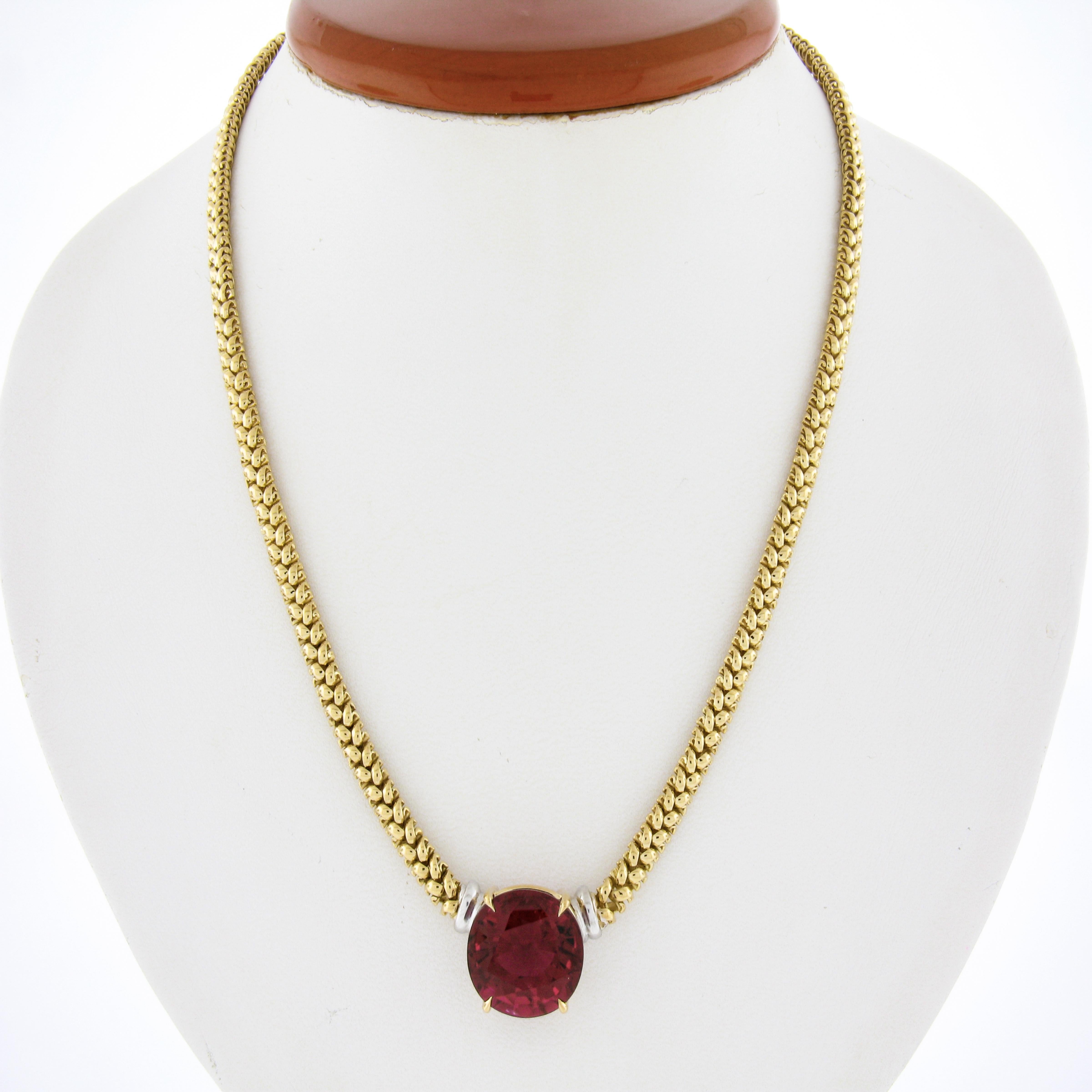 An estate statement solitaire pendant necklace that was crafted from solid 18k yellow gold. The necklace features a large, GIA certified oval shape rubellite tourmaline. It displays the finest and most mesmerizing raspberry red color that is