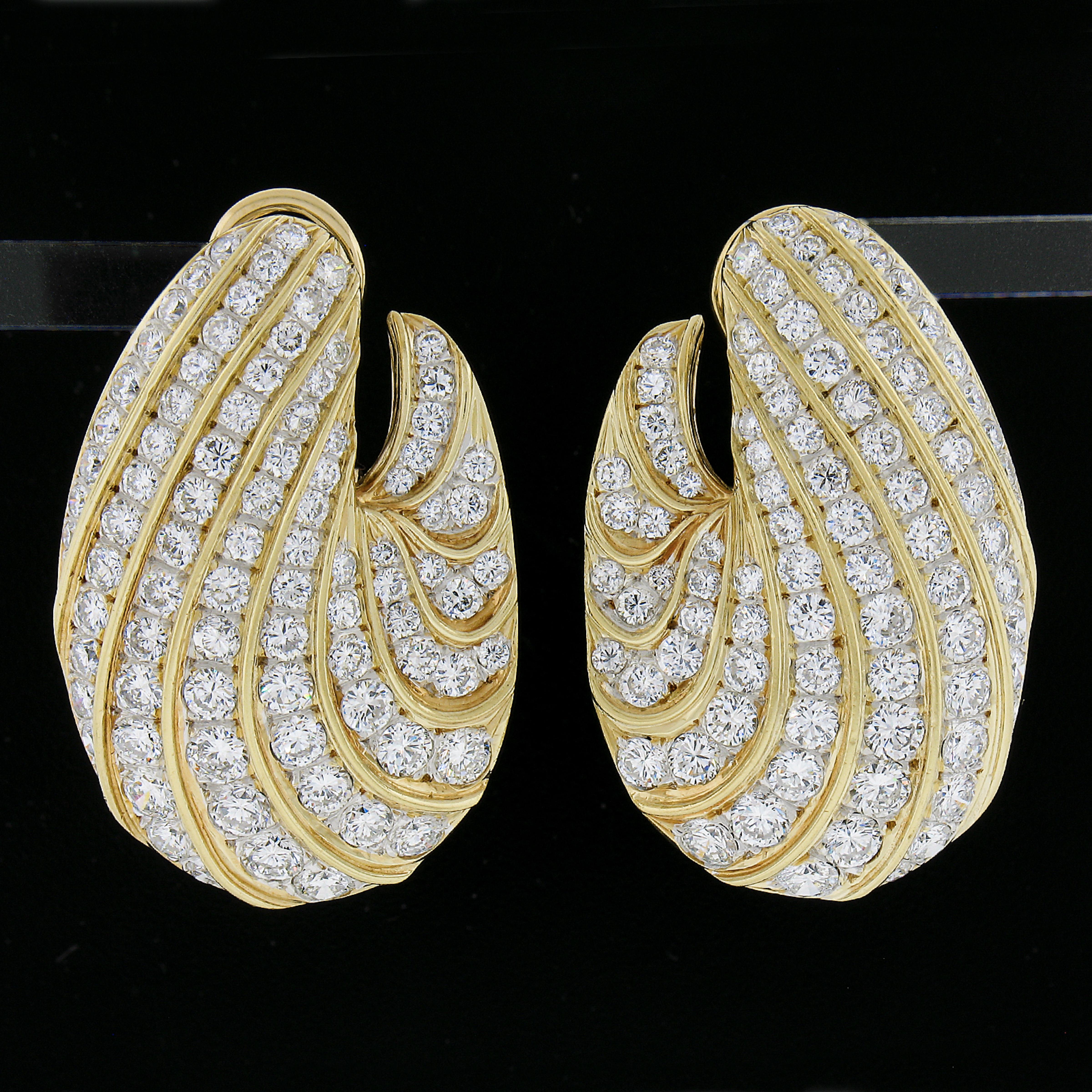 Very wearable and elegant style of earring with a white gold base and yellow polished curved lines outlining the diamonds. The diamonds graduate in size from smaller to larger to flow with the design and shape of the earrings. The diamonds are very