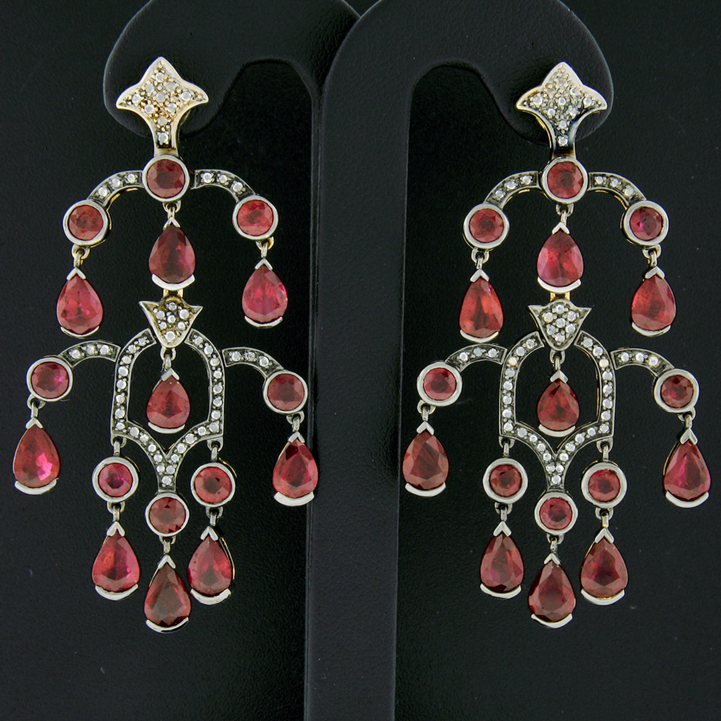 This gorgeous and large pair of drop chandelier earrings were crafted from solid 18k black gold with yellow gold backings and feature fine rubies and diamonds throughout. The rubies consist of both round brilliant and pear cut, in which 2 of the