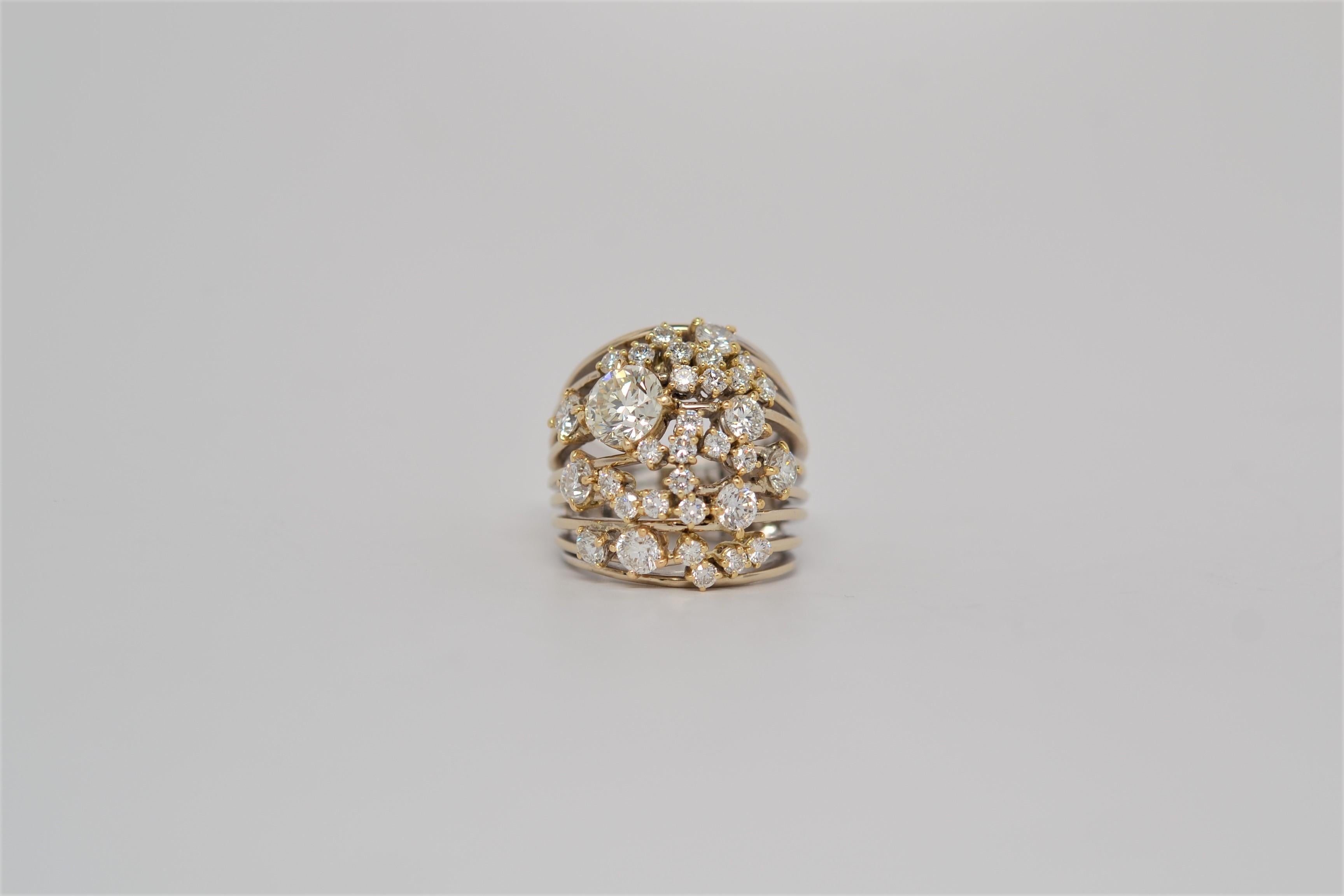 One ladies' 18K Two Tone Gold Ring with Round Brilliant Cut Diamonds. The cluster ring layout uses 18K White Gold shanks with 18K Yellow Gold baskets to prong set the diamonds. A total of thirty two Round Brilliant Cut Diamonds weigh 4.11ct (the