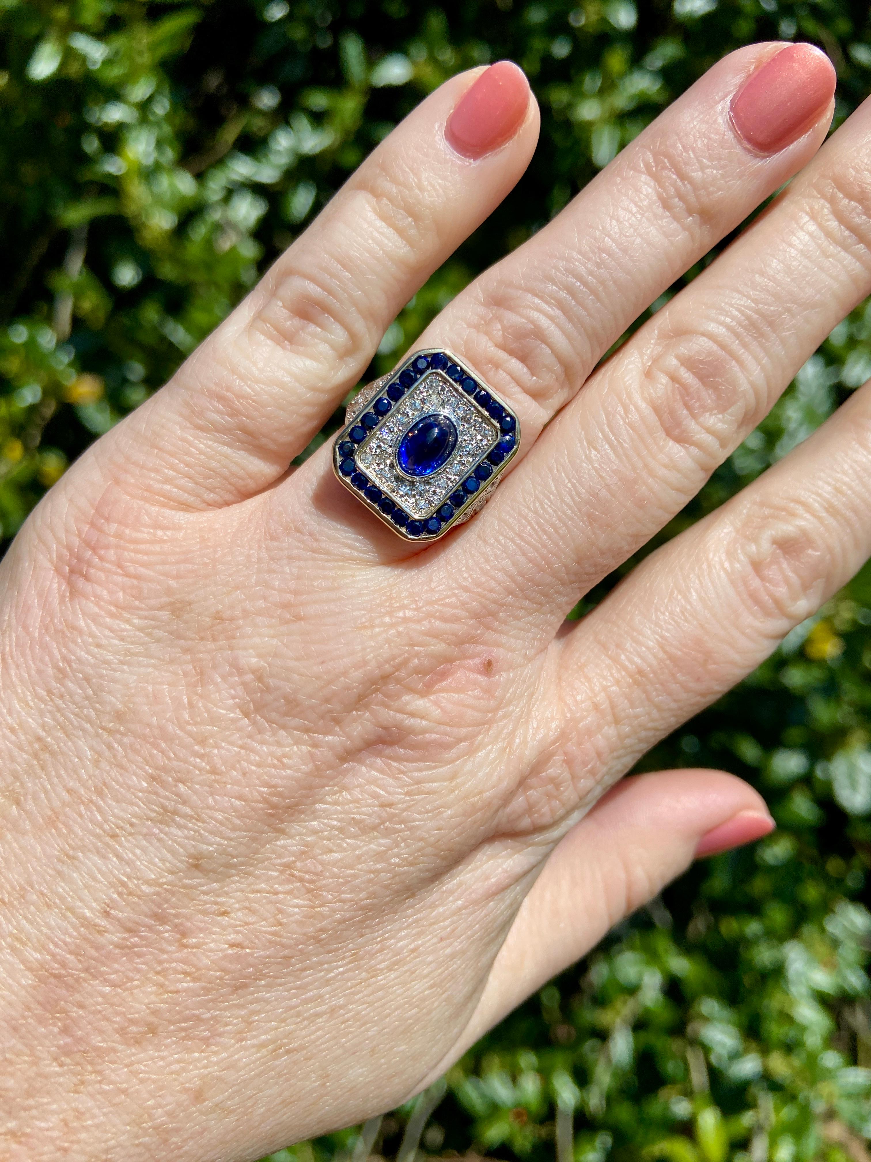 Un anello in oro bicolore 18k e platino con zaffiro cabochon e diamante. Incastonato in un letto di diamanti tondi brillanti da 0,40tcw con colore H/I e purezza SI, uno zaffiro ovale cabochon blu reale si trova al centro di questo anello a placca.