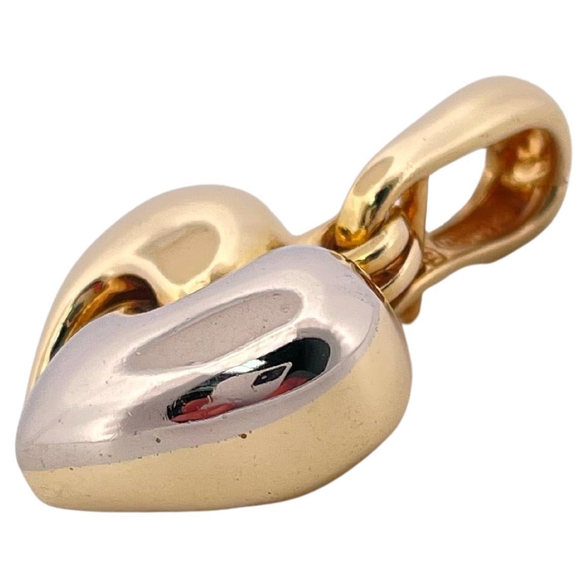 Cet élégant pendentif en forme de cœur bicolore 18 carats de Chimento met en valeur la signature du design italien contemporain de la marque. Réalisé en or jaune riche et en or blanc élégant, le pendentif présente deux moitiés sculptées qui se