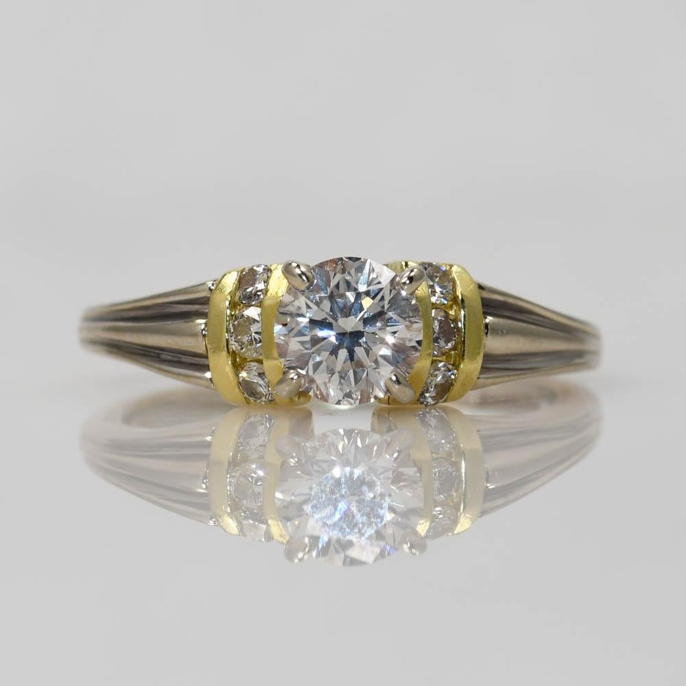 Diamond wedding ring set in 18k white and yellow gold.
Stamped 18k and weighs 6.5 grams.
The center diamond is a round brilliant cut, .75 carats, H color, Si clarity, excellent cut.
The side diamonds are round brilliant cuts, .15 total carats, i