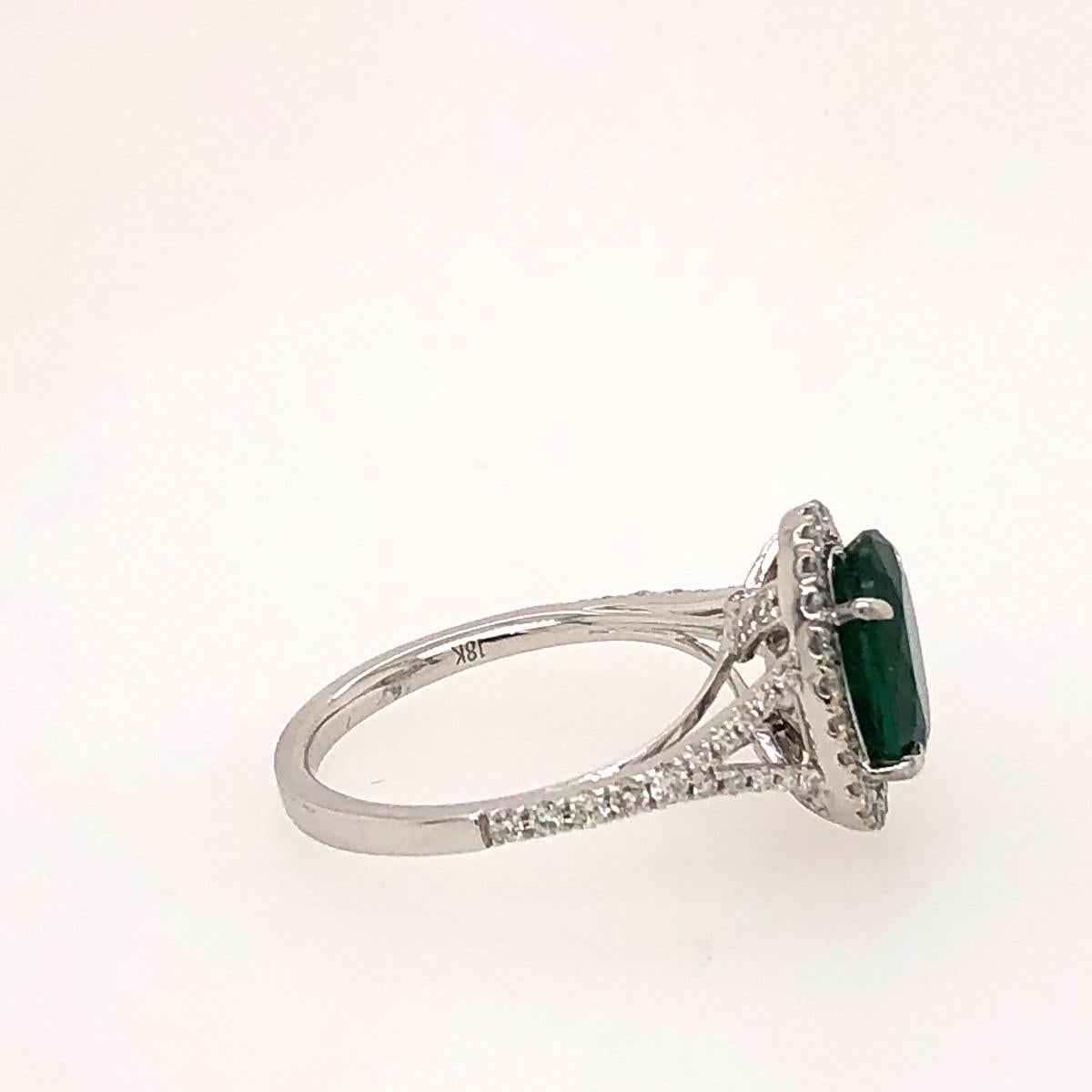 Style: Green Emerald Ring Surrounded With Diamonds On The Shanks 

Metal type: 18kt white and yellow gold 

1 2.01ct oval vivid green emerald 

0.53cts of Brilliant diamonds on the shanks 

Location Of Stone: Zambia 

Has 1 CDC Certificate. CDC