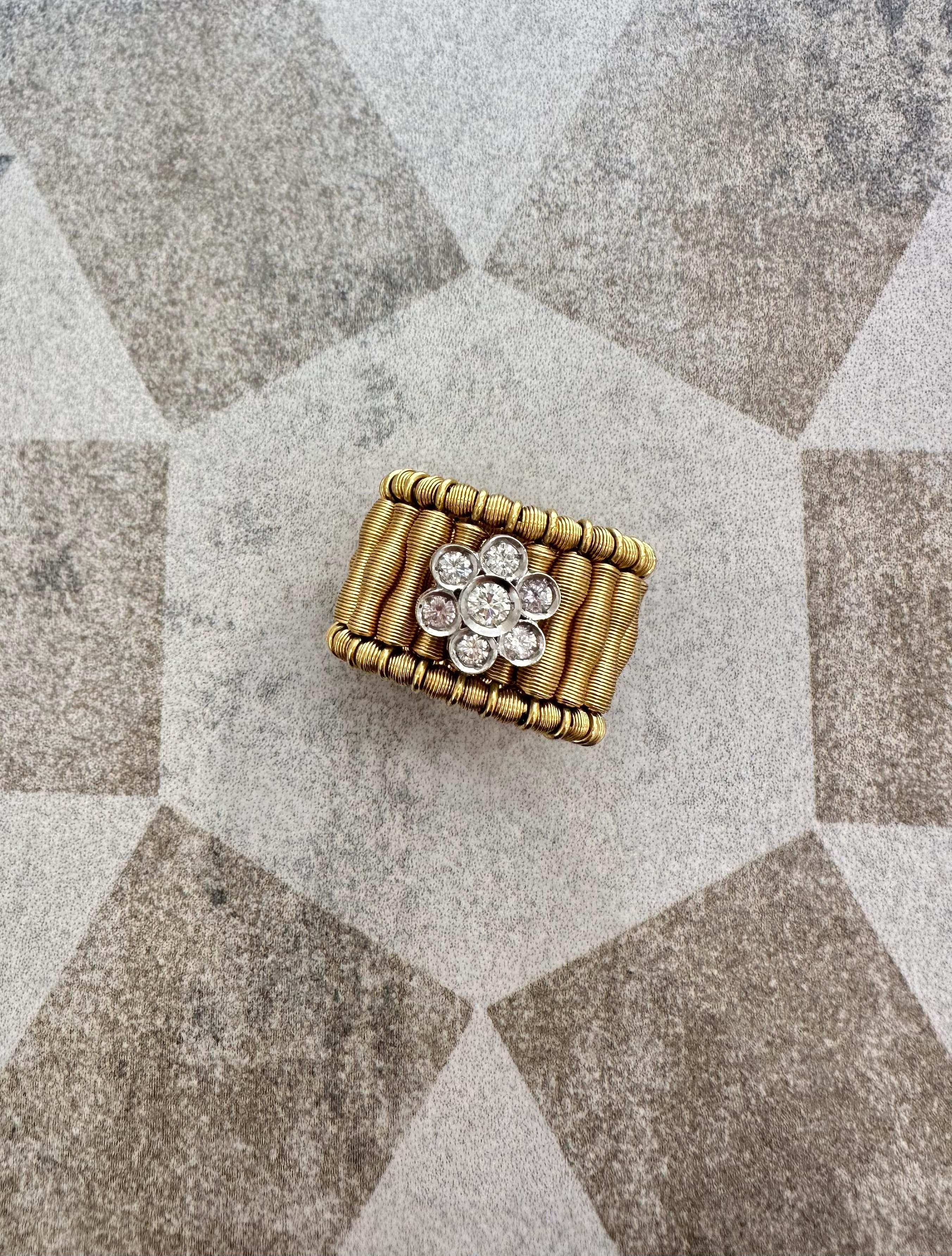 Dieser Jarretière-Ring aus 18 Karat zweifarbigem Gold zeichnet sich durch ein skulpturales, mit Diamanten besetztes Blumendesign aus. Die Blume besteht aus einzeln gefassten Steinen in Weißgold, die in geschichteten, blütenblattartigen Formen