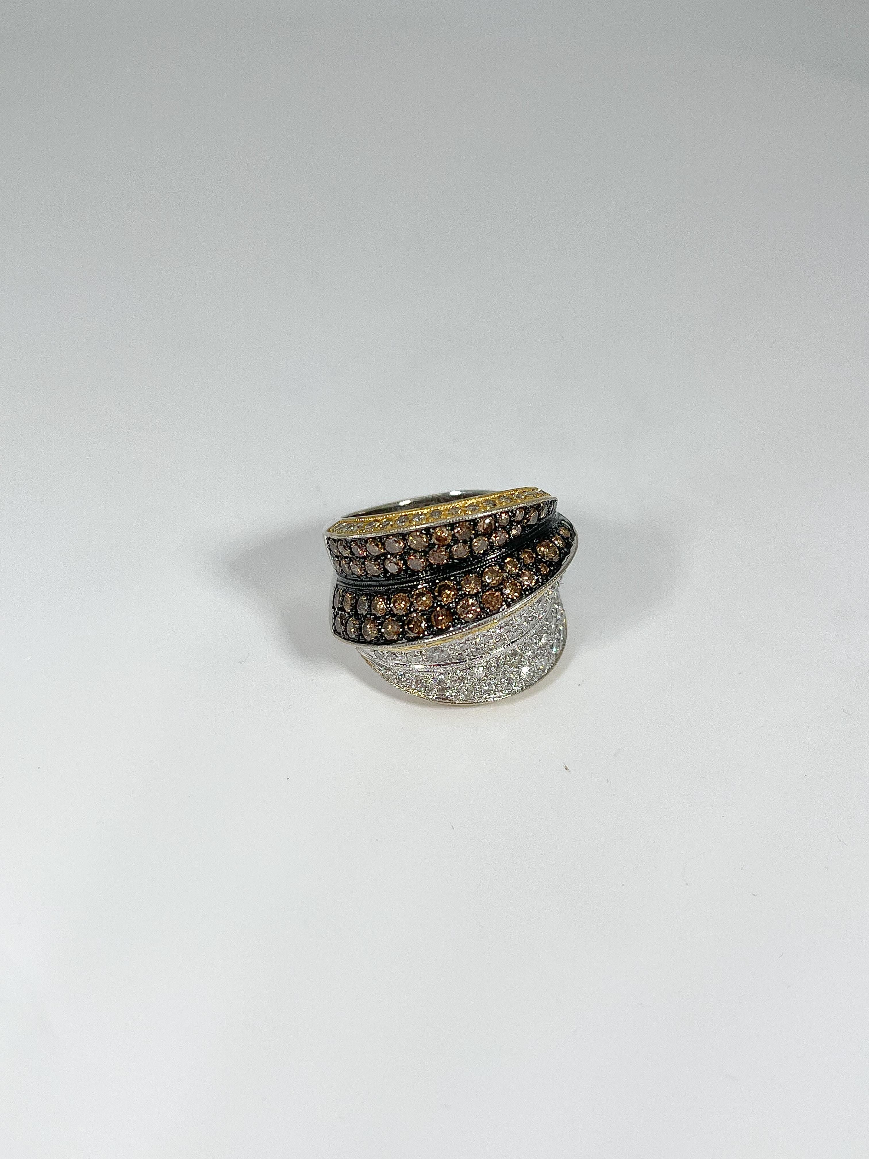 This unique two-toned cocktail ring has a black rhodium and is set with 107 white diamonds and 52 chocolate diamonds. Ring measures 19.5 mm. Fits a size 6 1/4 finger and weighs 15.56 grams.