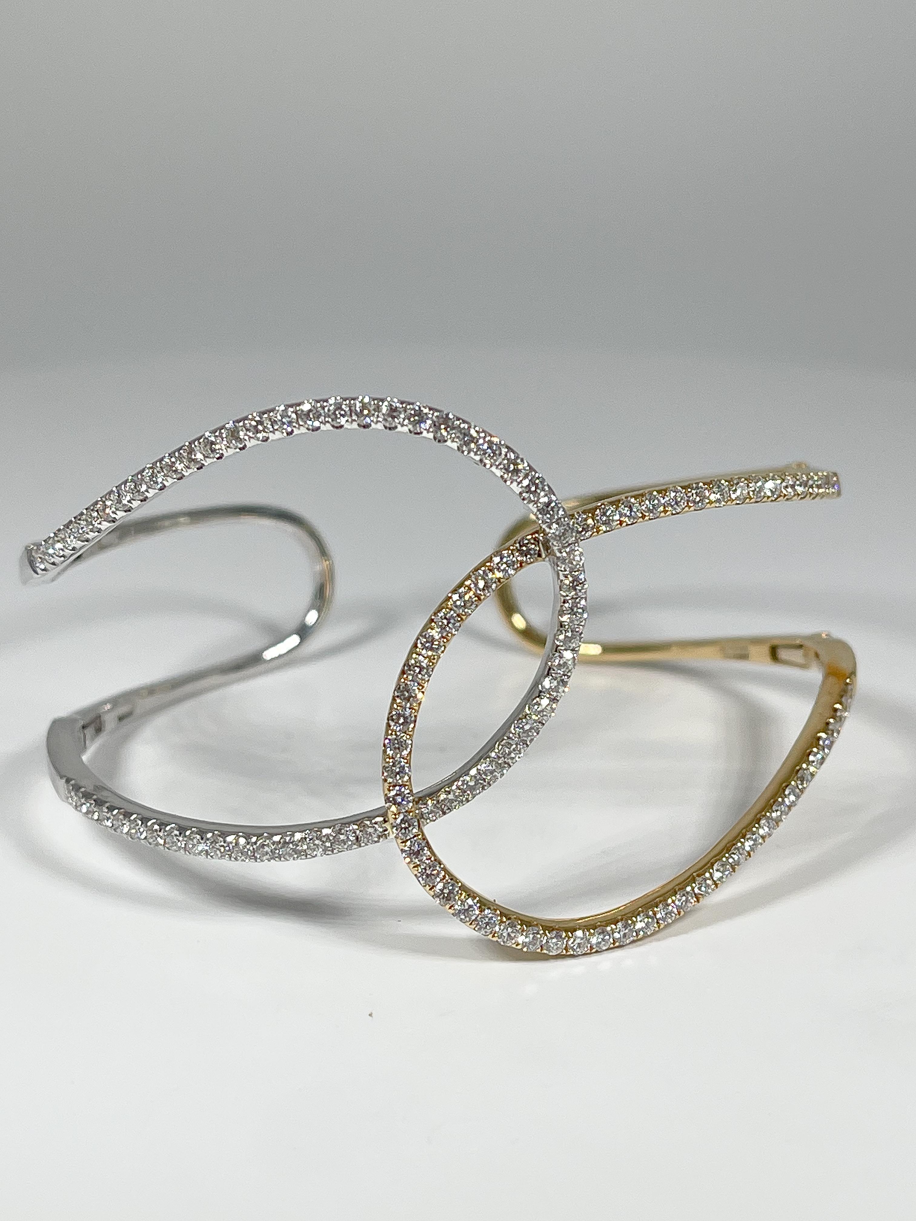 One of a kind 18k two toned white and yellow gold swirl bangle with diamonds, 2.32 ctw 
Retractable arms on bracelet for easy wearing
Will fit wrists up to size 7 1/2
1.5 inches wide 
Weight is 24.6 grams
Brand new condition, never worn