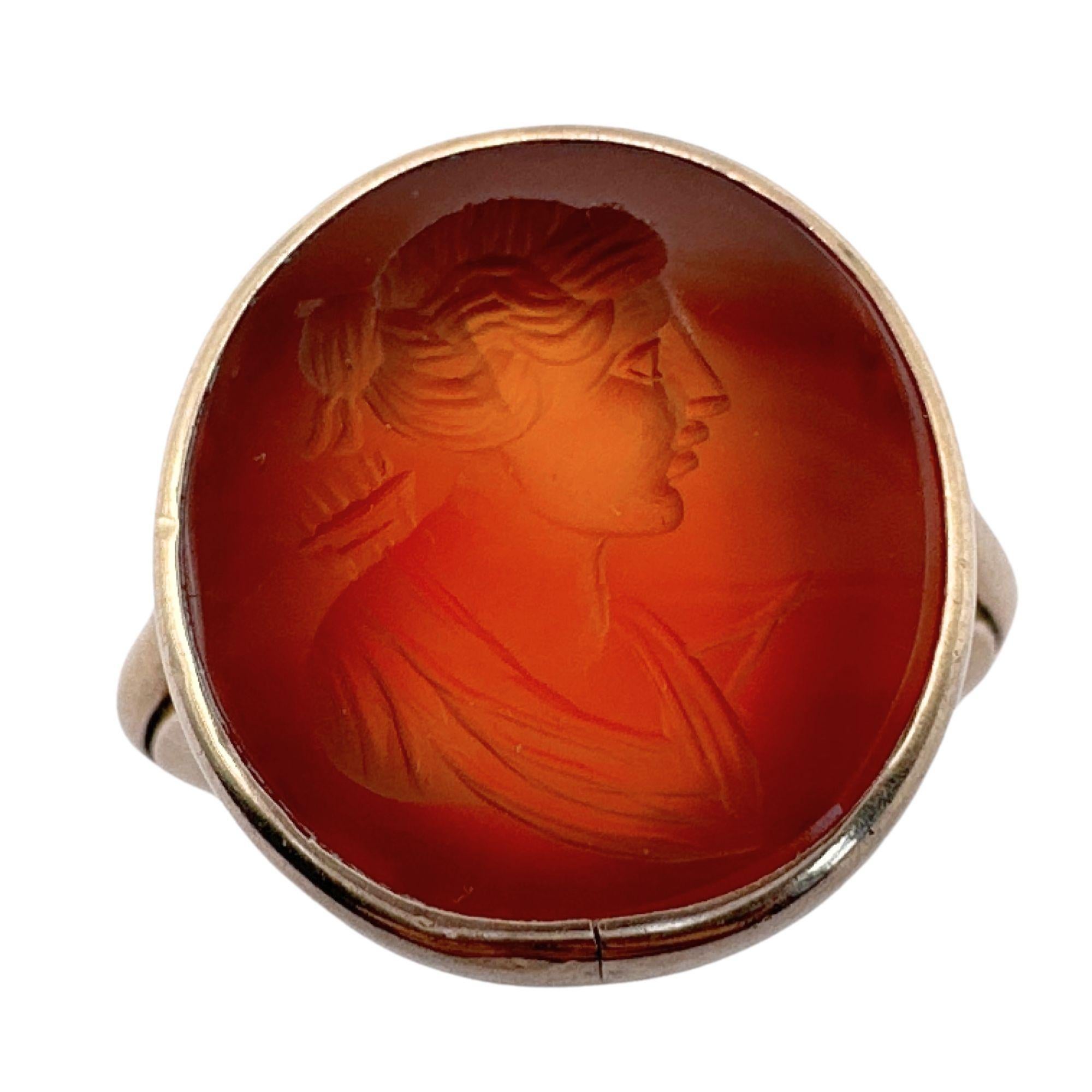 This beautiful Victorian 18k Carved Carnelian Ring is in good condition with minor surface wear. The intricate carving of the genuine Carnelian stone adds a touch of elegance and charm to this unique piece. Made of 18k gold and weighing 6.9 grams,