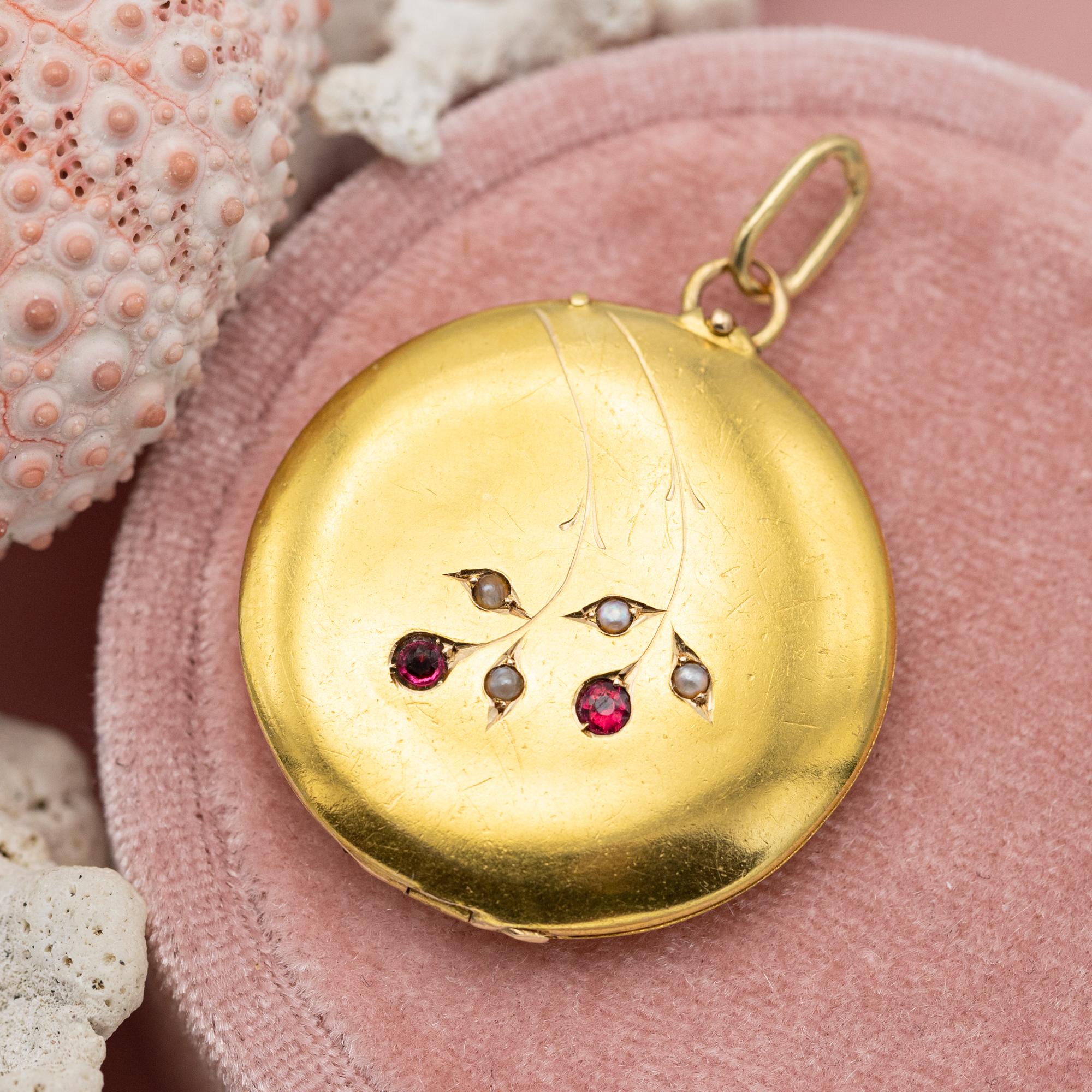 Zum Verkauf steht dieses wunderbare viktorianische 18 Karat zierliche Foto Medaillon aus massivem Gelbgold mit herrlichen Verzierungen. Die Vorderseite ist mit einer kleinen, aber schönen Saatperle und zwei rosaroten Rubinen besetzt. Feine