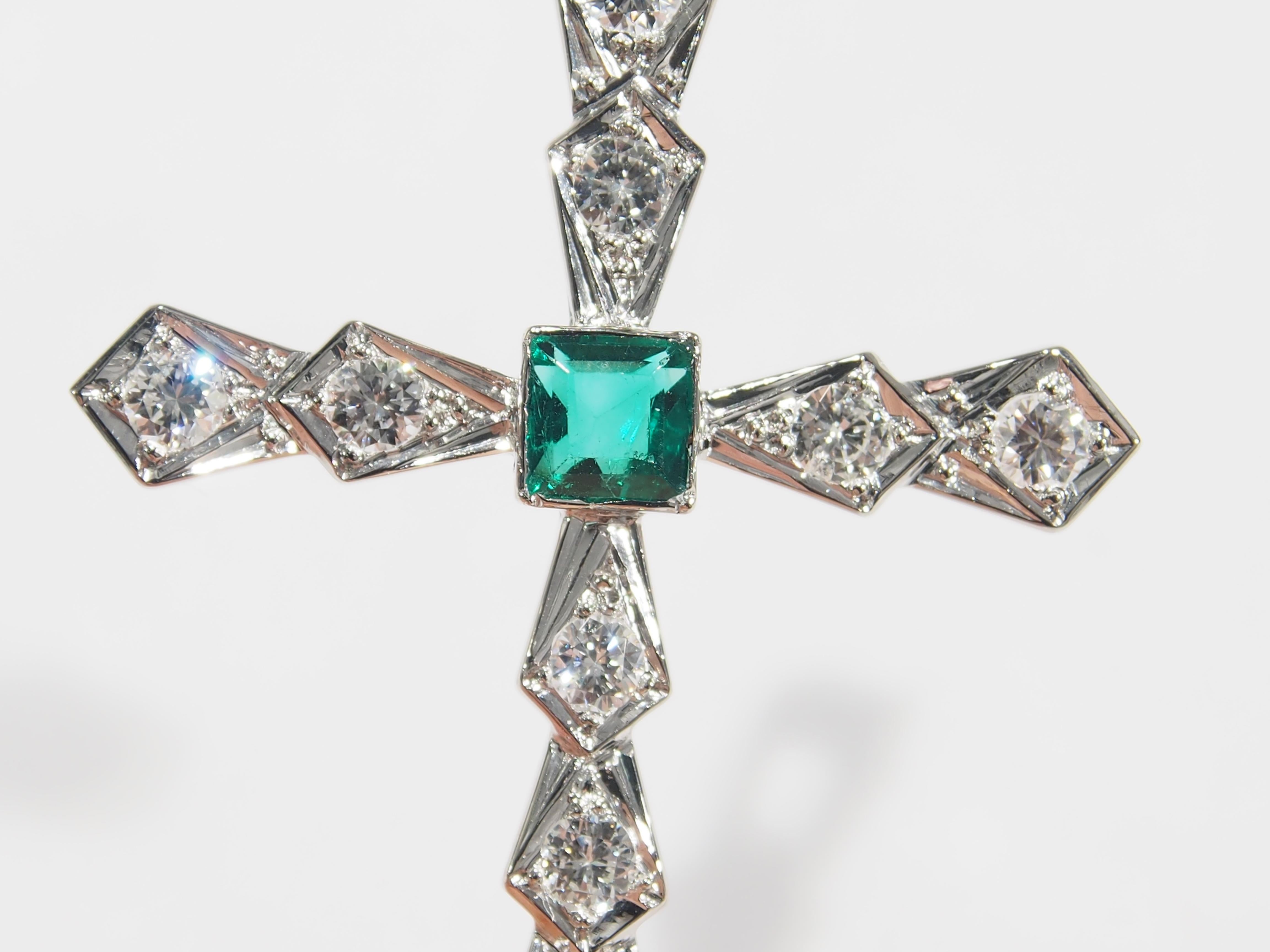 This is a unique 18K White Gold Cross Charm handmade with interlocking triangles. Set in each Triangle are (12) Round Brilliant Cut Diamonds, approximately 1.00ctw, G-H in Color, VS in Clarity that are accented by (1) Square Step Cut Emerald,