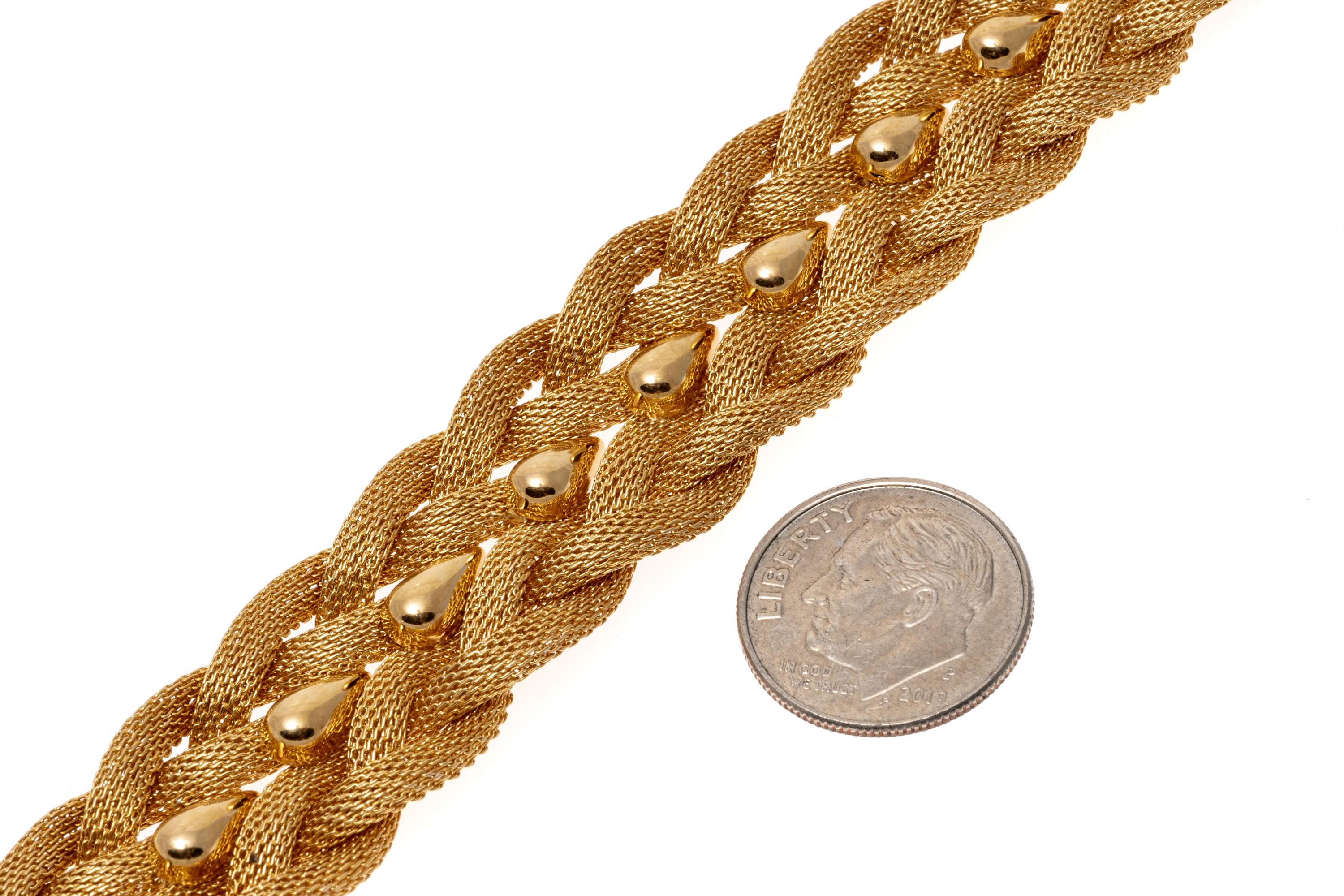Ce magnifique bracelet vintage est composé de deux rangées de mailles tressées à finition mate, centrées par une goutte de pluie en or jaune poli. Le bracelet est doté d'un fermoir caché de type boîte avec une sécurité en huit.
Marques :