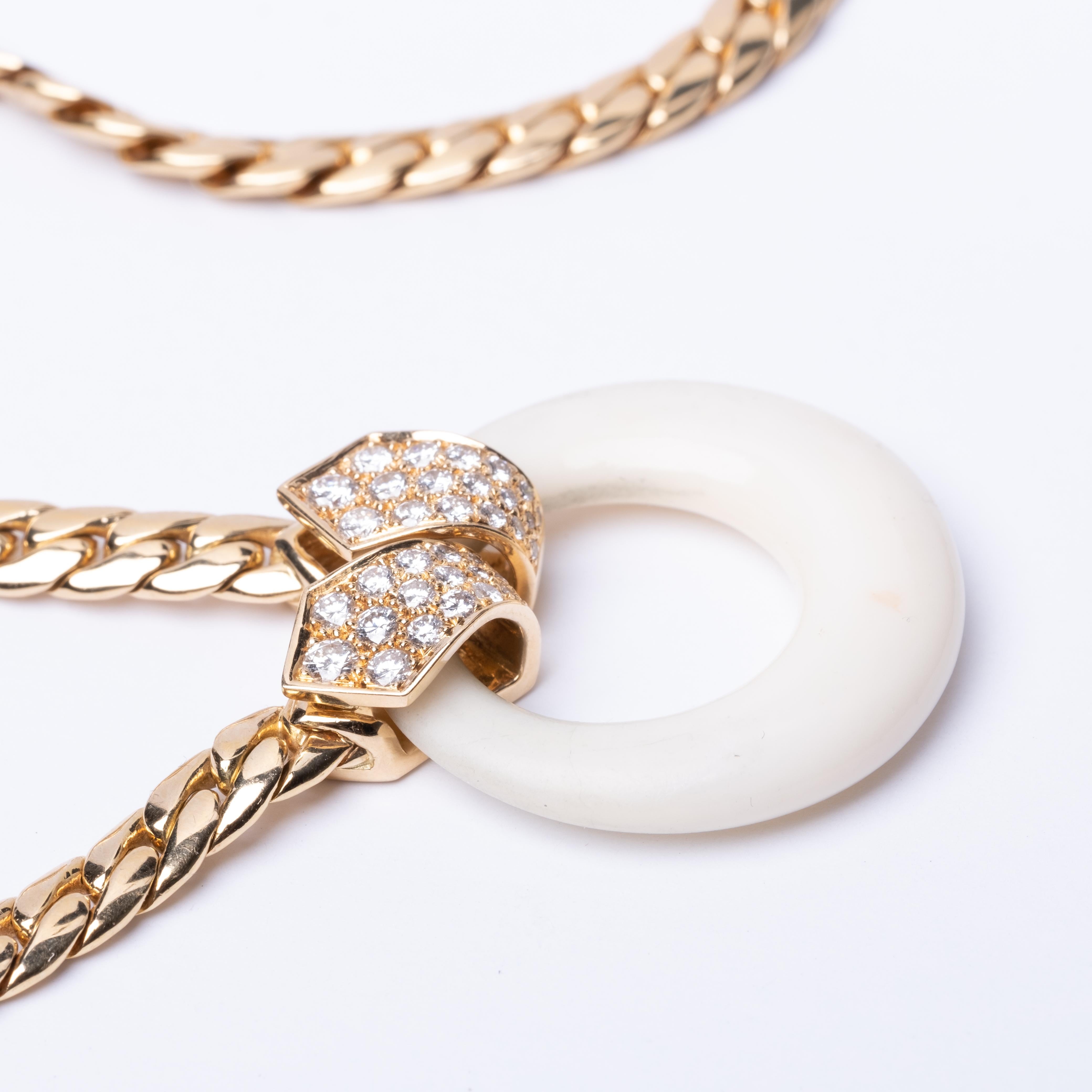 18K Van Cleef Arpels necklace Weighs 45.7 grams. It is presented with a 14K chain and a white coral pendant that measures 1.14 in length and 1.10 in width. The necklace is embellished with diamonds that feature E color and VVS clarity and amount to