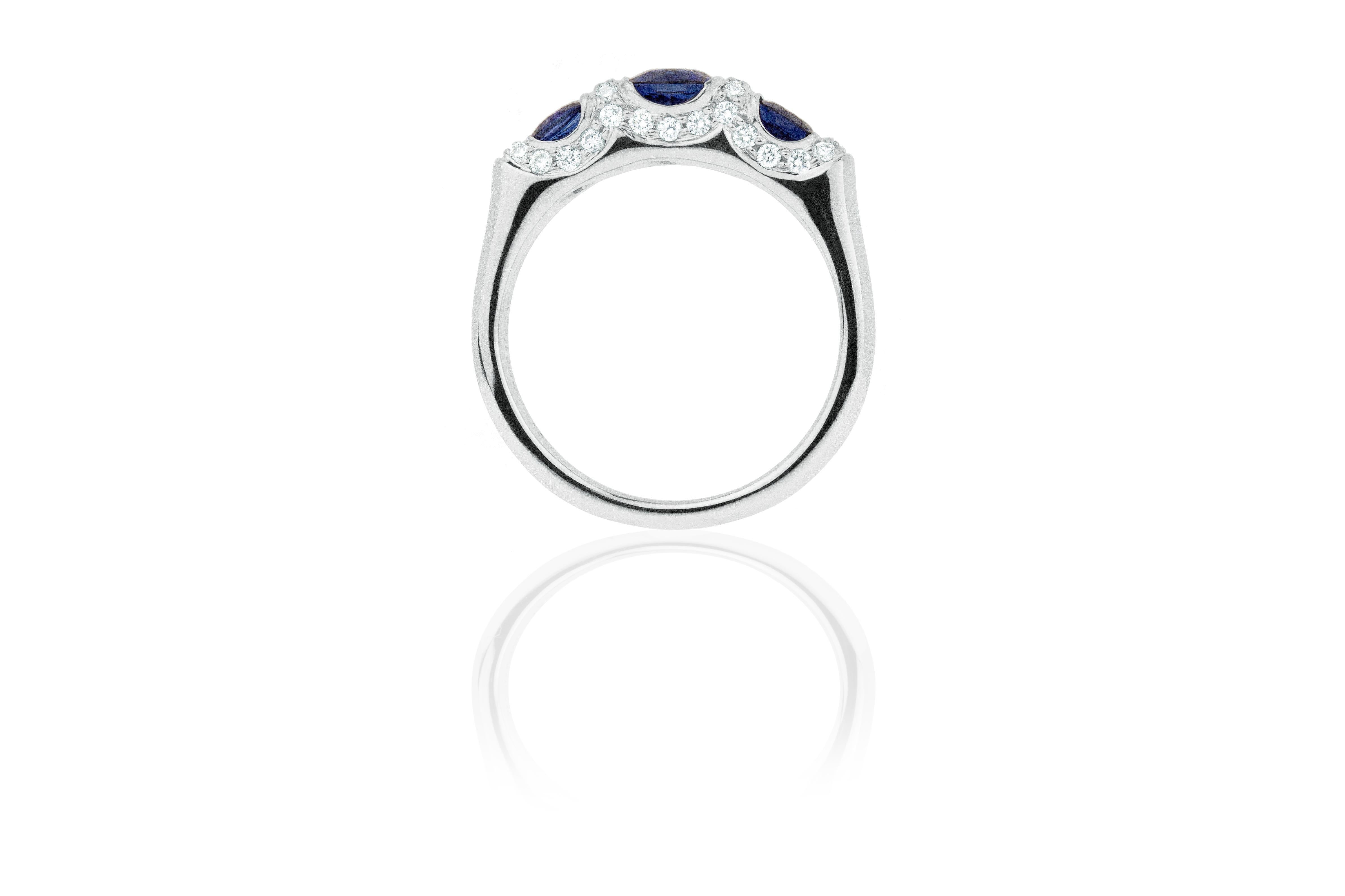 Three stunning blue sapphires with a total of 1.76 carats are skillfully set in 18 karat white gold, surrounded by a scalloped border of .33 carats of dazzling GH-VS diamond pave. The band tapers to a 3 mm shank for comfort. A romantic, everyday