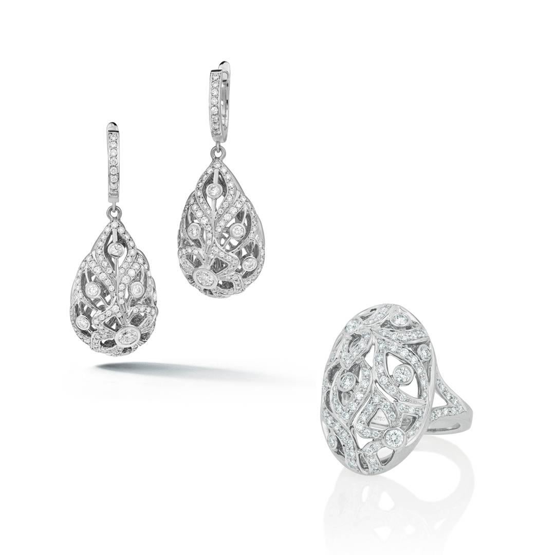 These romantic, floral 18k white gold pendant drop earrings feature 1.90 carats of dazzling GH-VS round diamonds set in sultry three-dimensional pear shapes.  The swirling floral motif pendants measure 1 inch long and hang affixed to a pave diamond