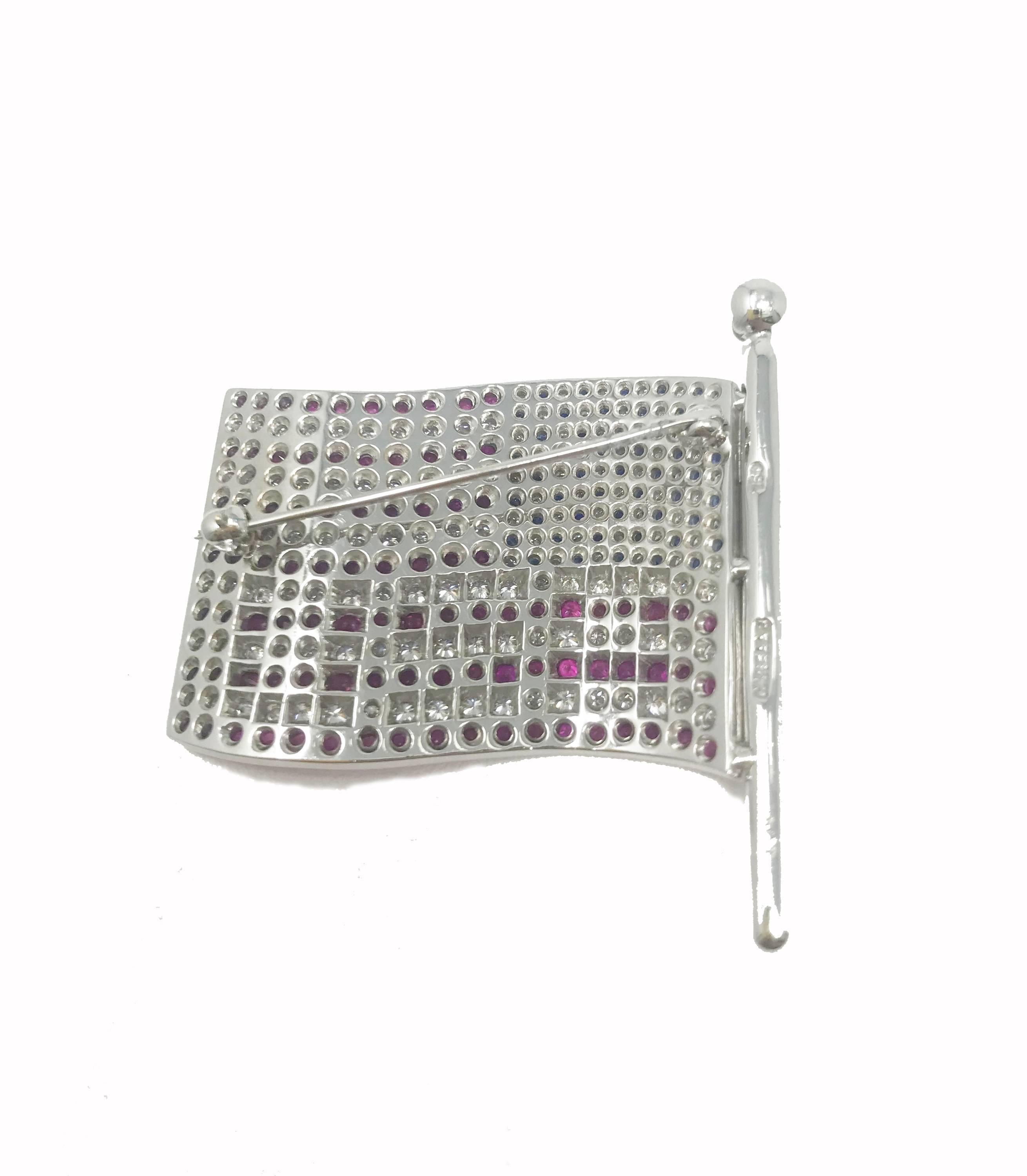 Show your patriotism with this 3-dimensional American flag brooch pin made in 18 karat white gold and accented by a whopping 2.04 carats of dazzling GH-VS round pave diamonds, .55 carats of blue sapphire and 3.15 carats of ruby.  This stunning USA