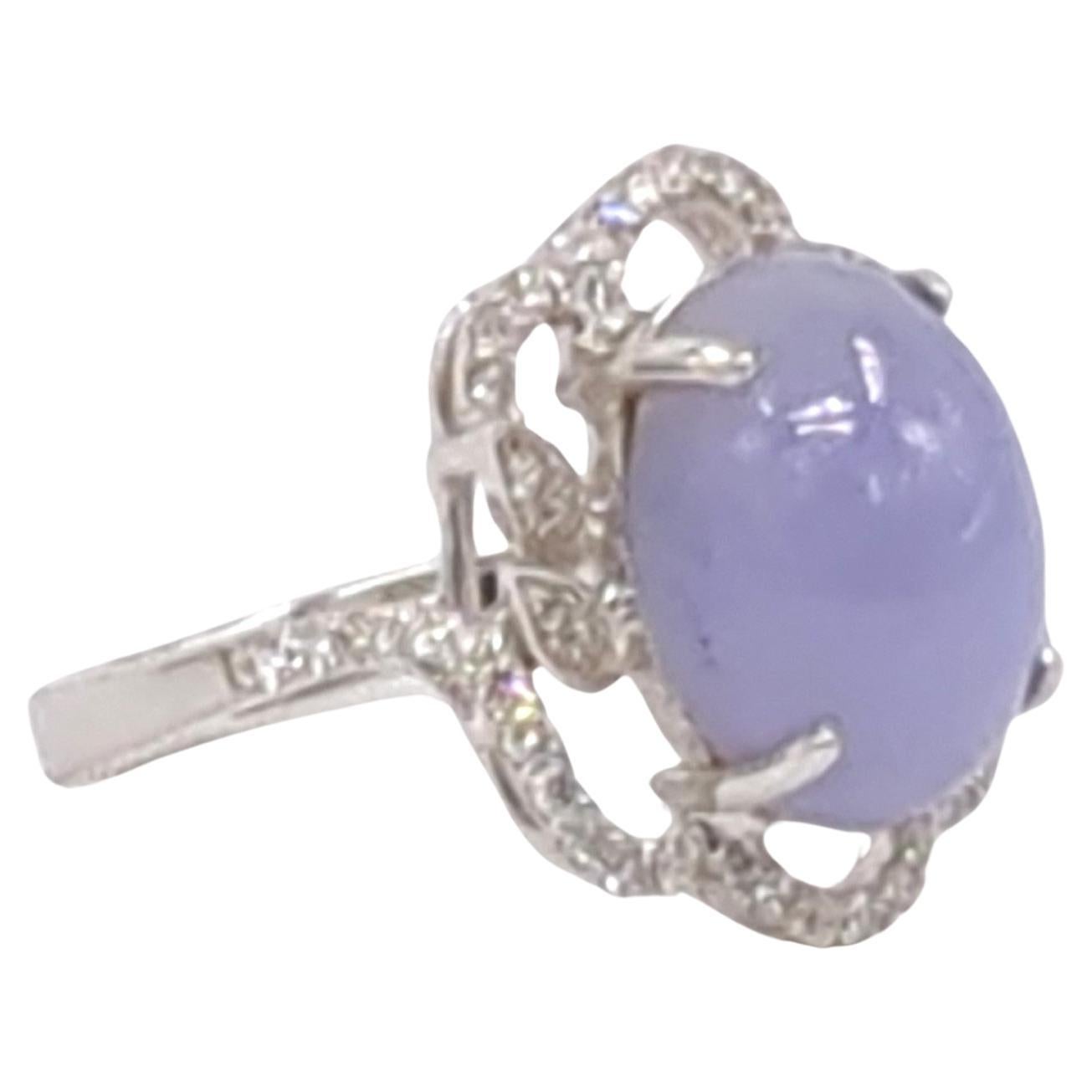 This exquisite ladies' ring is a true work of art, skillfully crafted in 18K white gold and weighing 5.10 grams. At the center of its design lies a captivating oval cabochon of lavender jadeite, which has been certified as A-grade by the NGTC. The