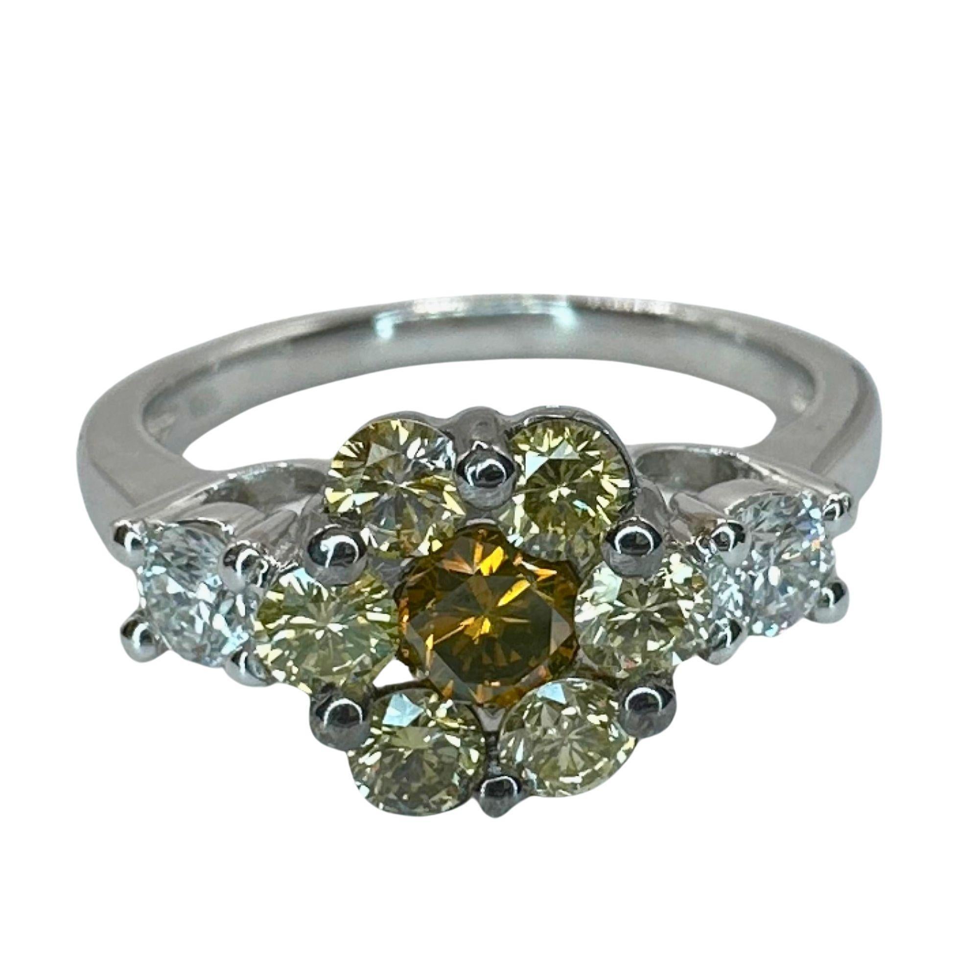 This cute 18k white and yellow diamond flower ring weighs 4.70 grams and features 0.26 carats of white diamonds and 0.80 carats of yellow diamonds. In good condition, it showcases intricate markings and a size 7.75 band. Perfect for adding some