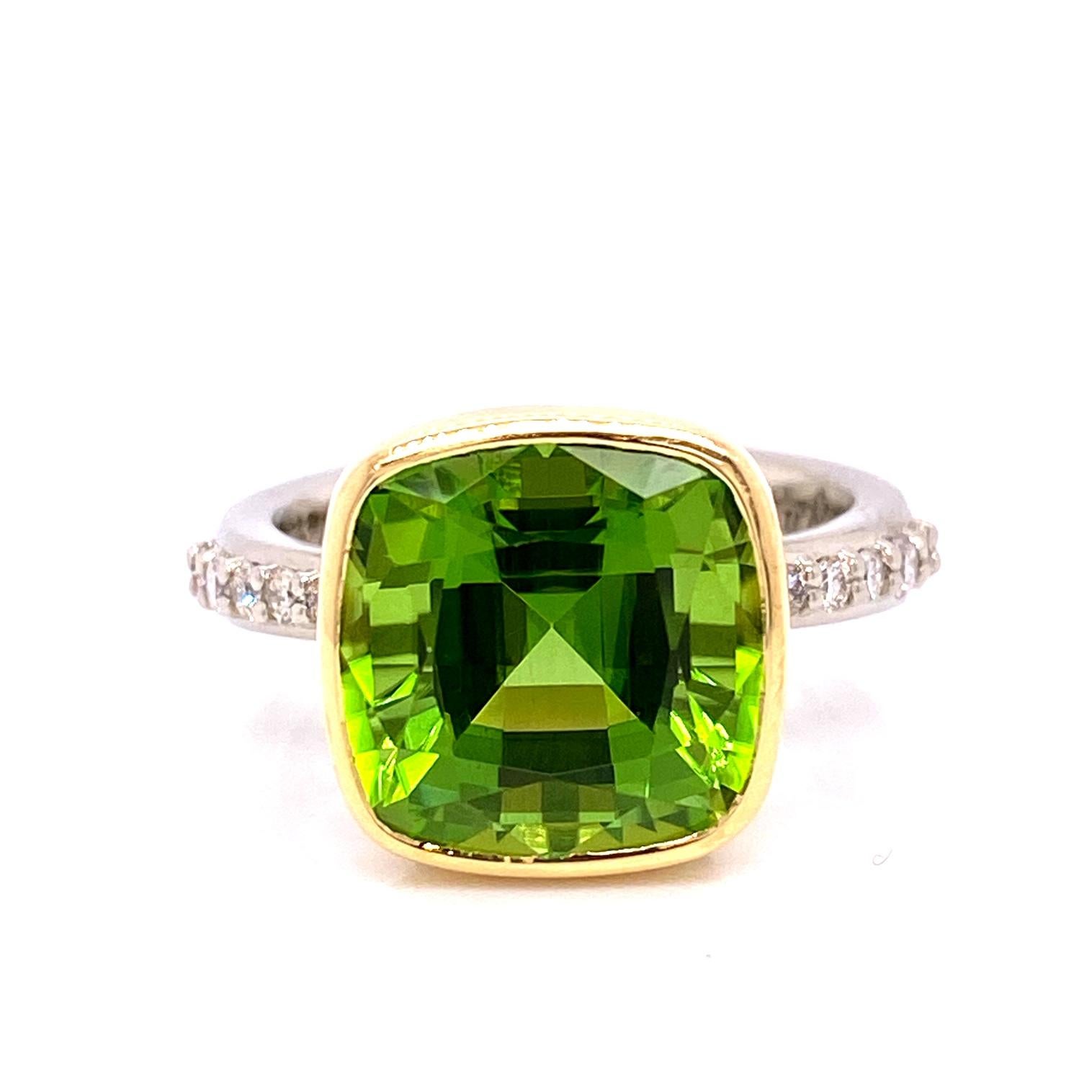 An 18k white and 18k yellow gold ring bezel set with a 7.96 carat cushion cut faceted peridot with ten round full cut white diamonds, 0.20 total carat weight F color VS clarity. This ring was custom designed and made by llyn strong.