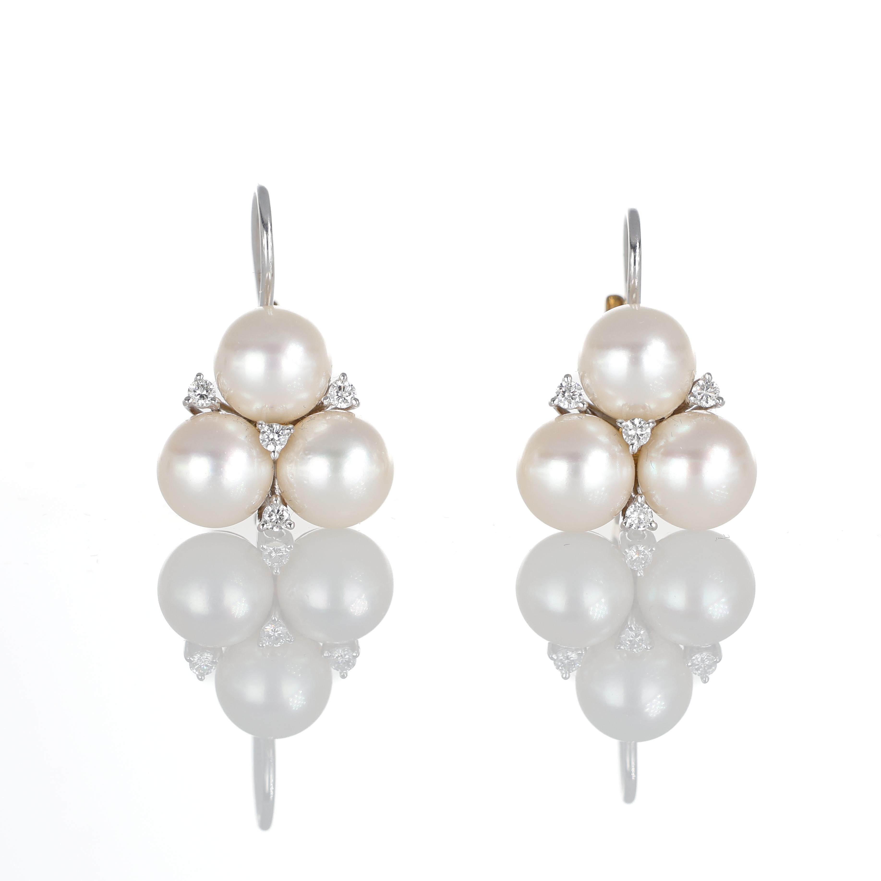 A delicate balance of elegance and craftsmanship, these earrings feature a harmonious combination of white and yellow gold, accentuated by luminous pearls and brilliant-cut diamonds. The triangular arrangement of pearls enhances their natural