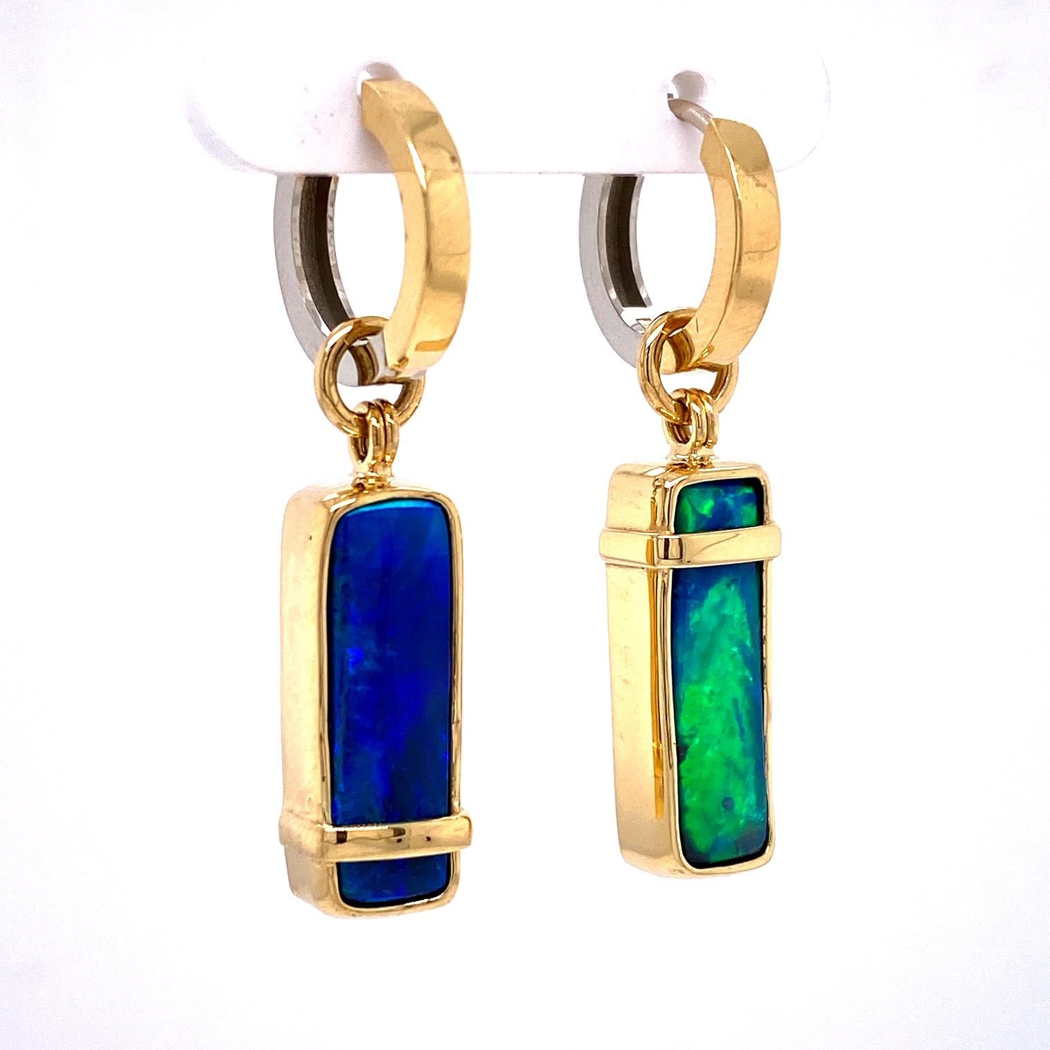 A pair of reversible 18k white and yellow gold reversible huggie hoops, with a pair of 18k yellow gold earring jackets featuring two rectangular free form shaped Australian Boulder Opals 9.55 total carat weight. These earrings were designed and made