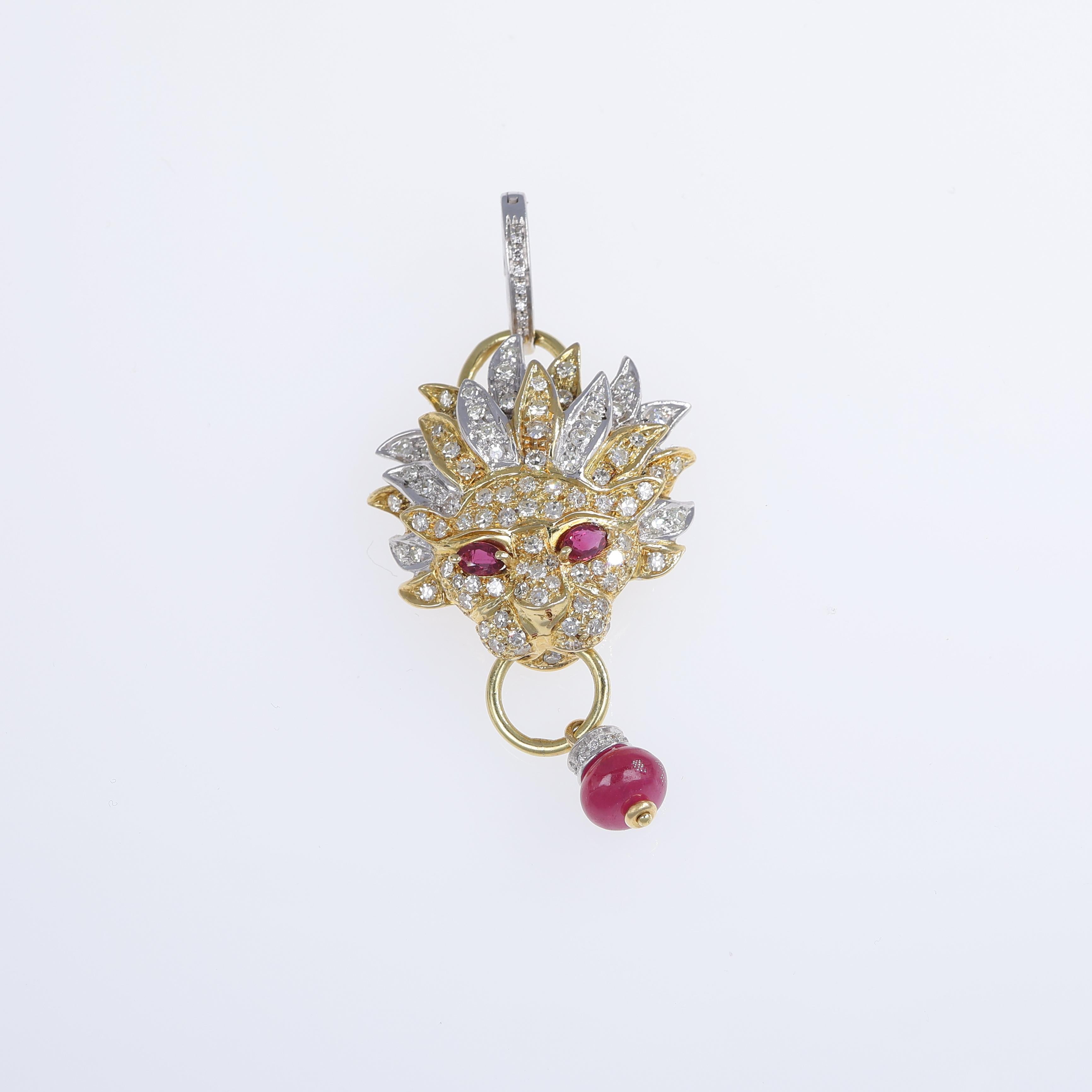 A majestic 18K white and yellow gold lion-shaped pendant, intricately designed with a pavé of natural white diamonds and captivating ruby eyes. The lion's fierce yet elegant expression is further enhanced by a dangling ruby cabochon, adding a regal