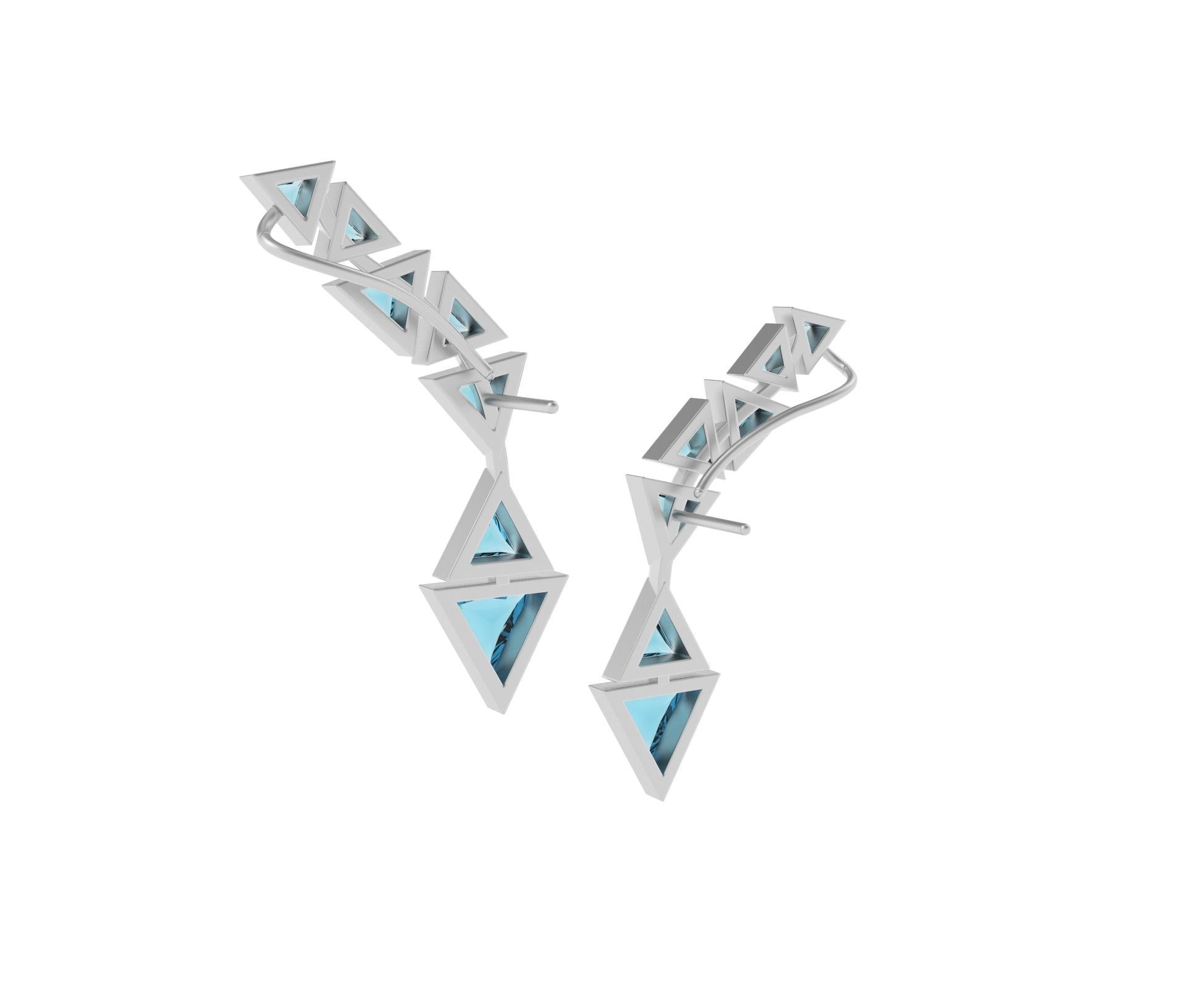 18k White Brushed Gold Cuff Earrings with Trillion Cut Blue Topaz.

These cuff earrings have been inspired by triangles that are seen a lot in Temples, Pagodas, and other religious places because the triangle symbolizes the power of the number