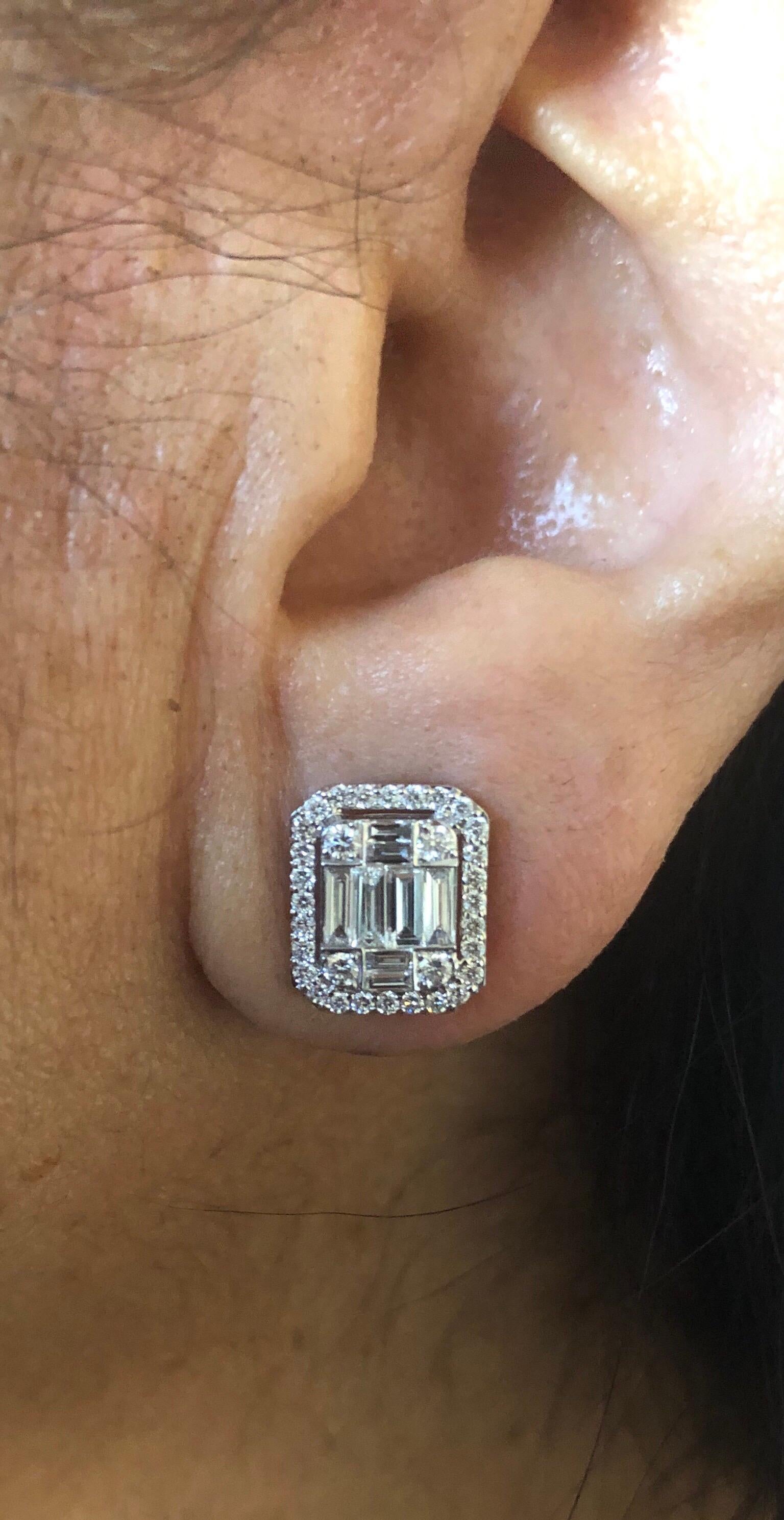 Emerald Cluster Earrings set in 18K white gold. The earrings are set with a cluster of baguette and round diamonds to create the illusion of a single emerald cut. This earring has the size of a 5 Carat Emerald cut stone. The total carat weight of