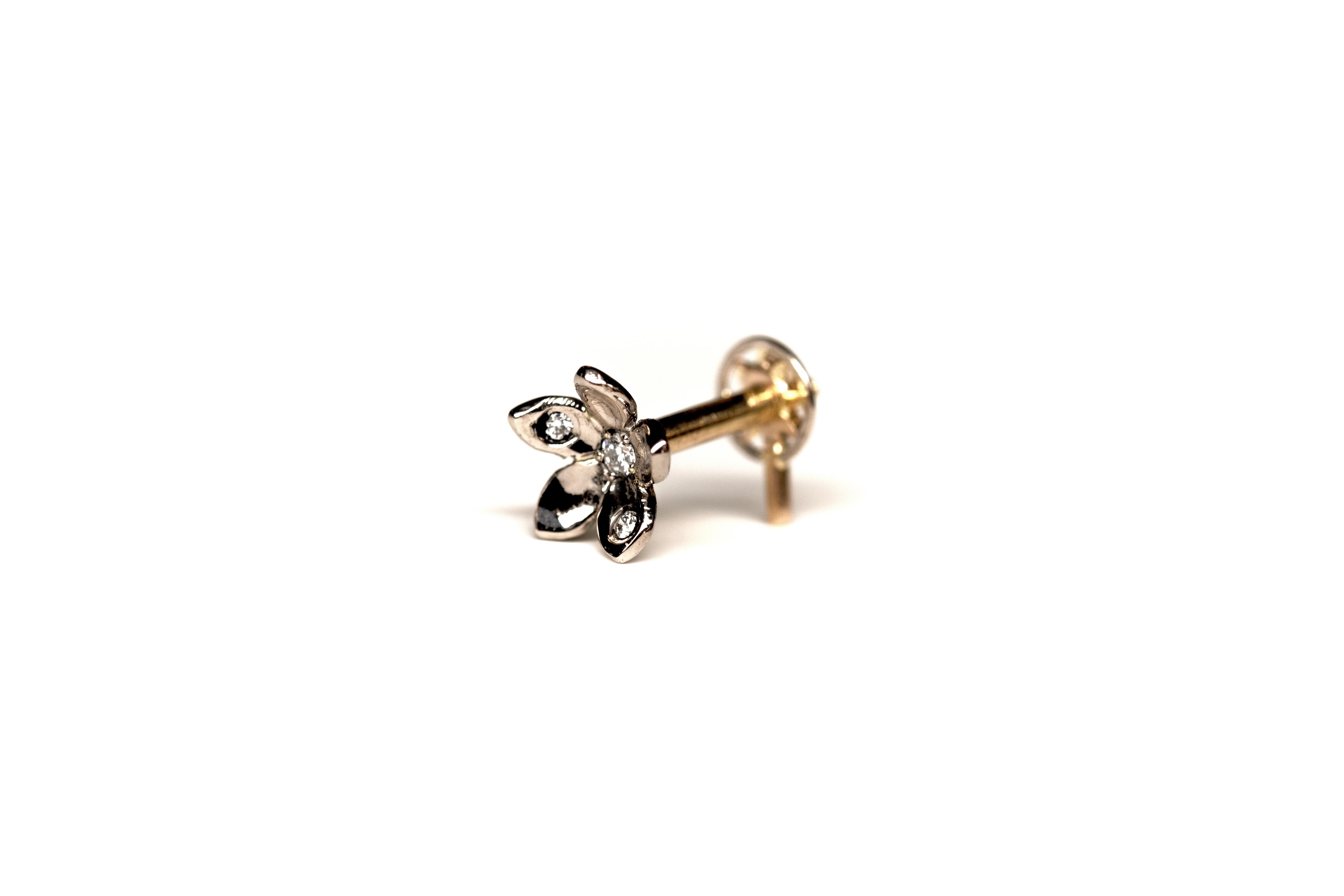Flower-shaped ear piercing, completely handmade from 18K yellow and palladium white Fairmined gold and Canadamark diamonds.

The flower screws into the star at the back. The screw is handmade. We suggest closing it gently and being careful not to