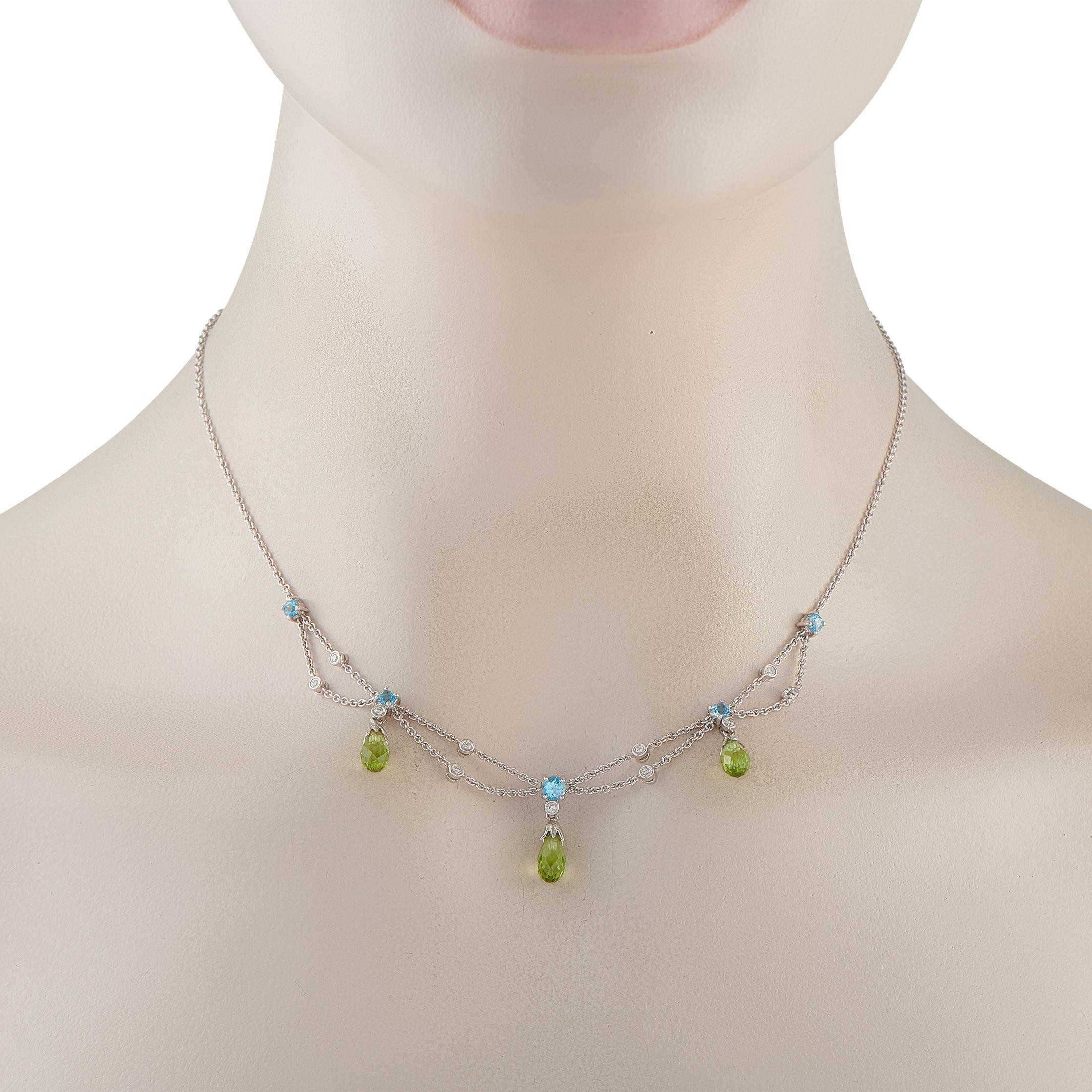 Este collar no te decepcionará si buscas una pieza que ofrezca un juego de luces cautivador y un brillo estratificado. Está fabricado en oro blanco de 18 quilates e incluye piedras de topacio azul cielo combinadas con peridotos en forma de lágrima.
