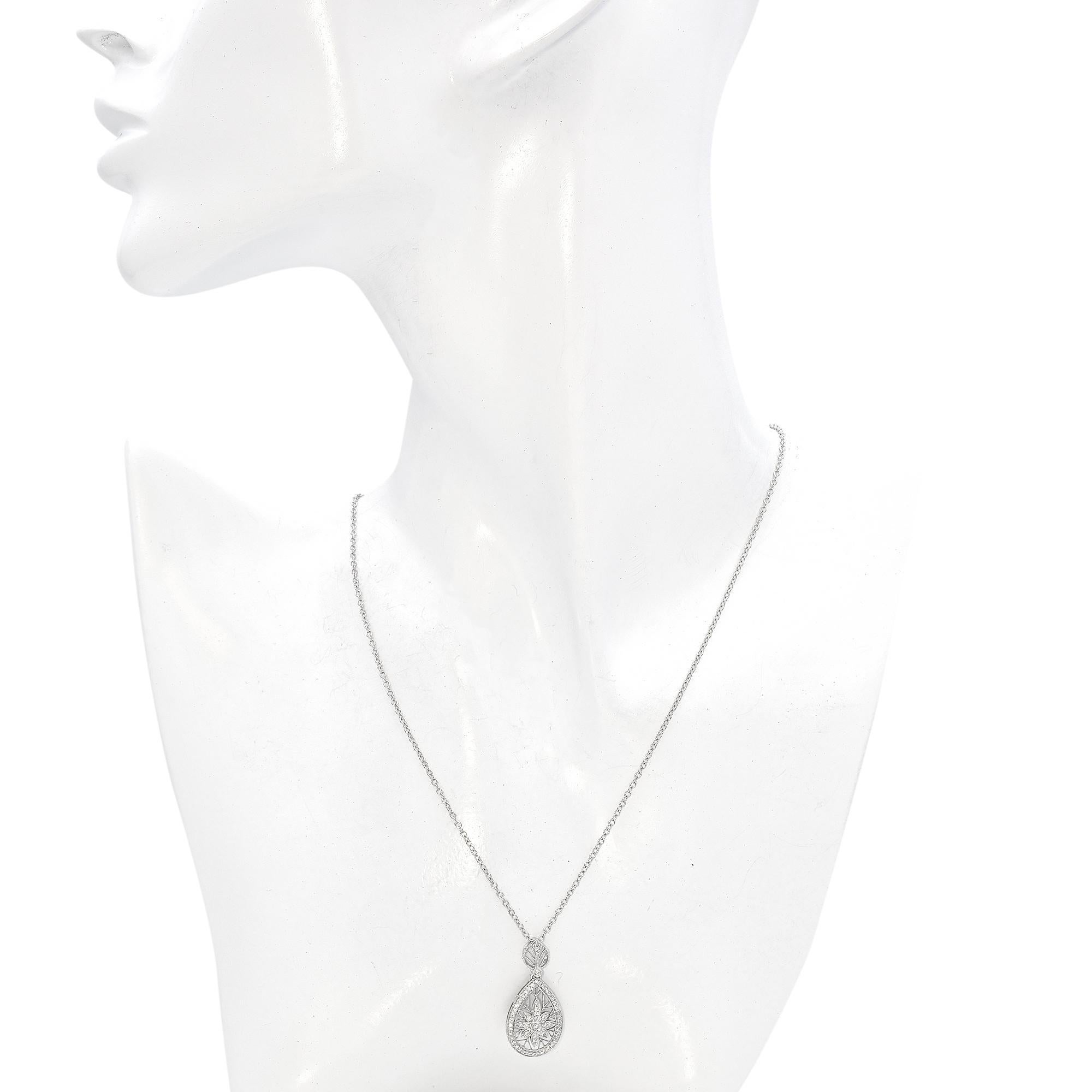 Experience the refined beauty of this Diamond Pendant Necklace. Made from 18k white gold, the pendant showcases 0.22 carats of round-cut white diamonds. The design features an intricate openwork teardrop adorned with a central floral motif,