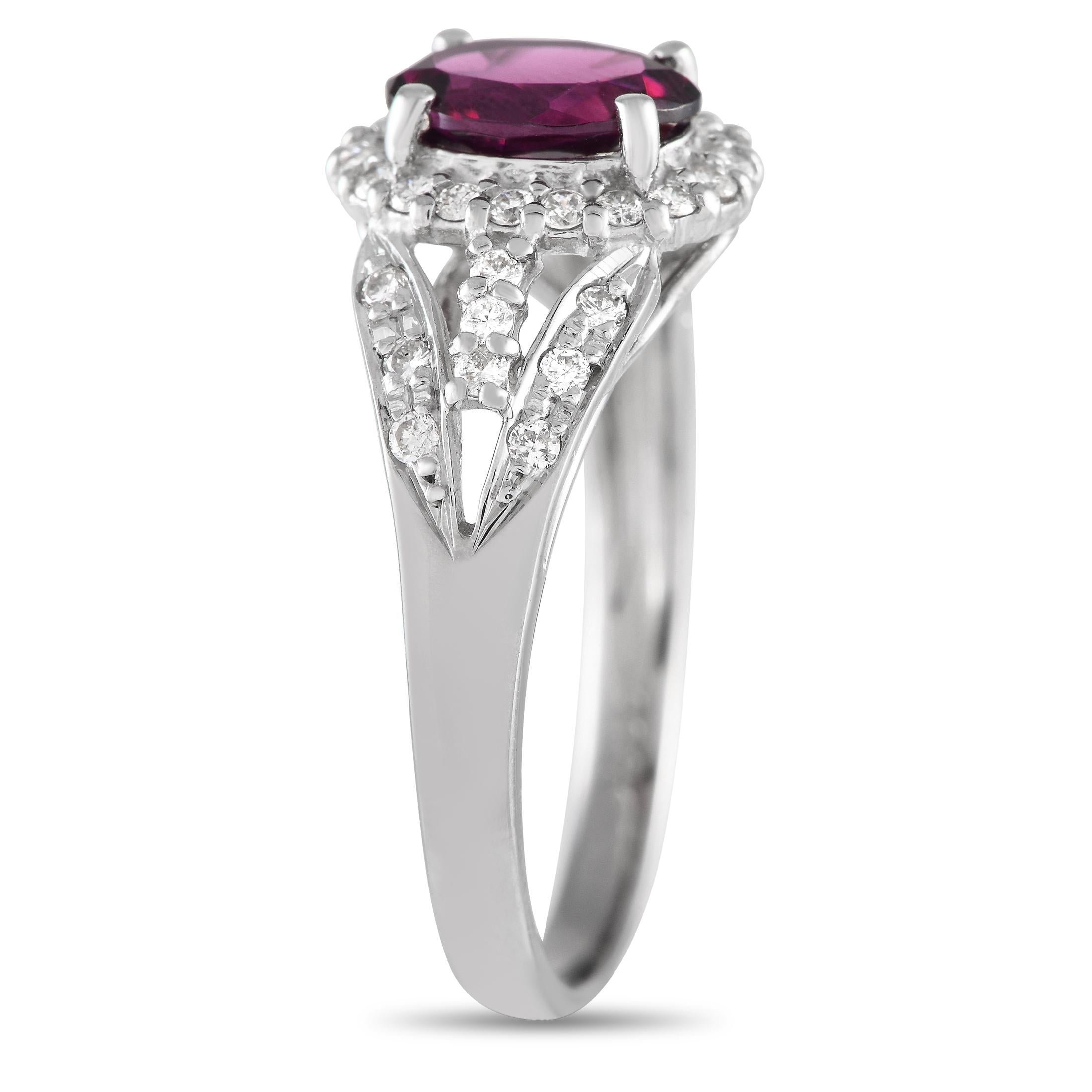 This ring, with its solid platinum split shank and rhodolite garnet centerstone, captures the idea of nostalgia. Petite round diamonds elegantly line the split shoulders and encircle the purplish-pink central gem. The ring's top dimensions measure