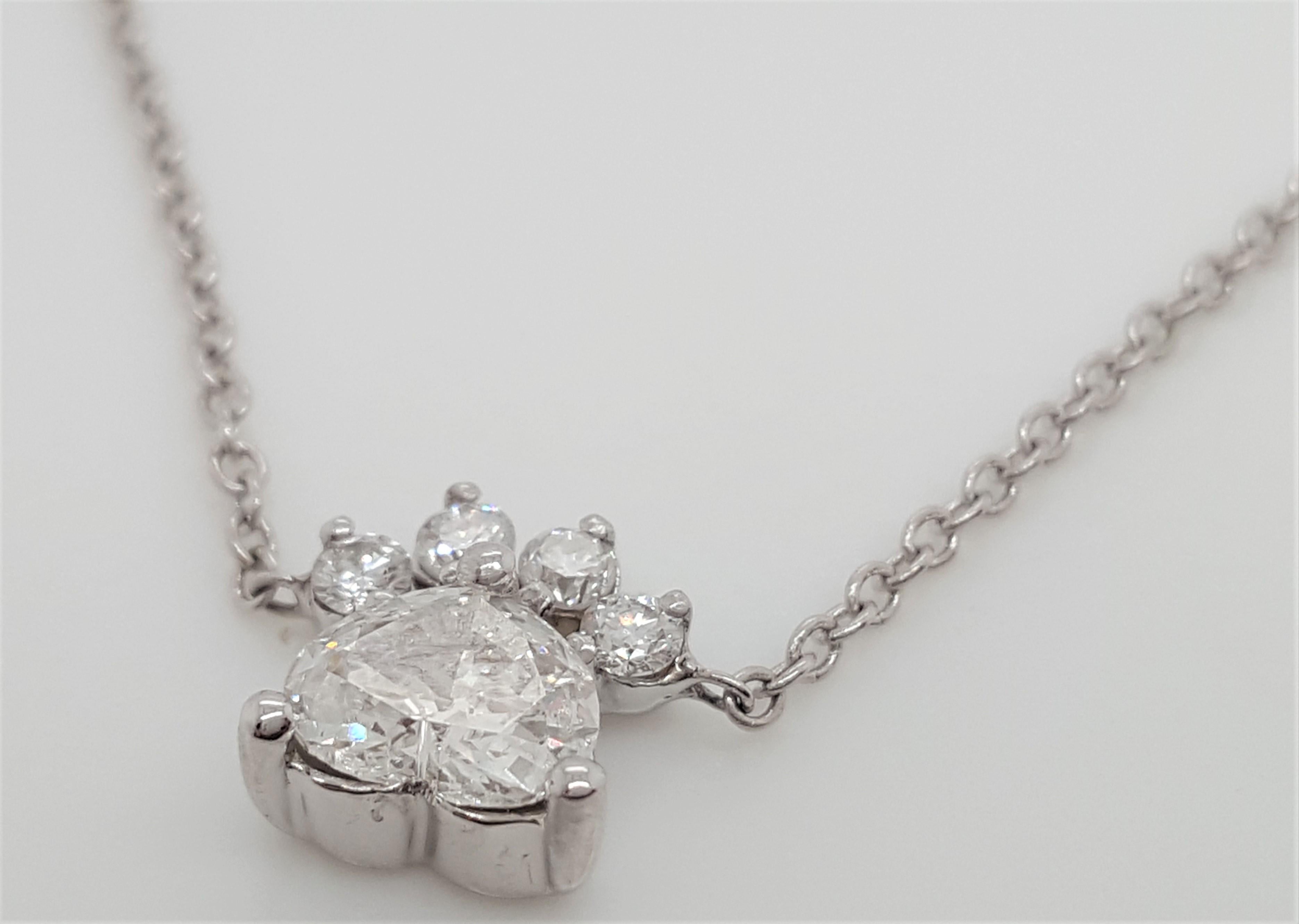 The Dog Paw Pendant Necklace includes a 0.33 carat heart  cut diamond center set in a basket setting hugged by 3 prongs and 4 Round Brilliant Cut Diamonds 0.06 ct tw  It is hanging on a 18K white gold 18” Cable chain. It is the perfect everyday