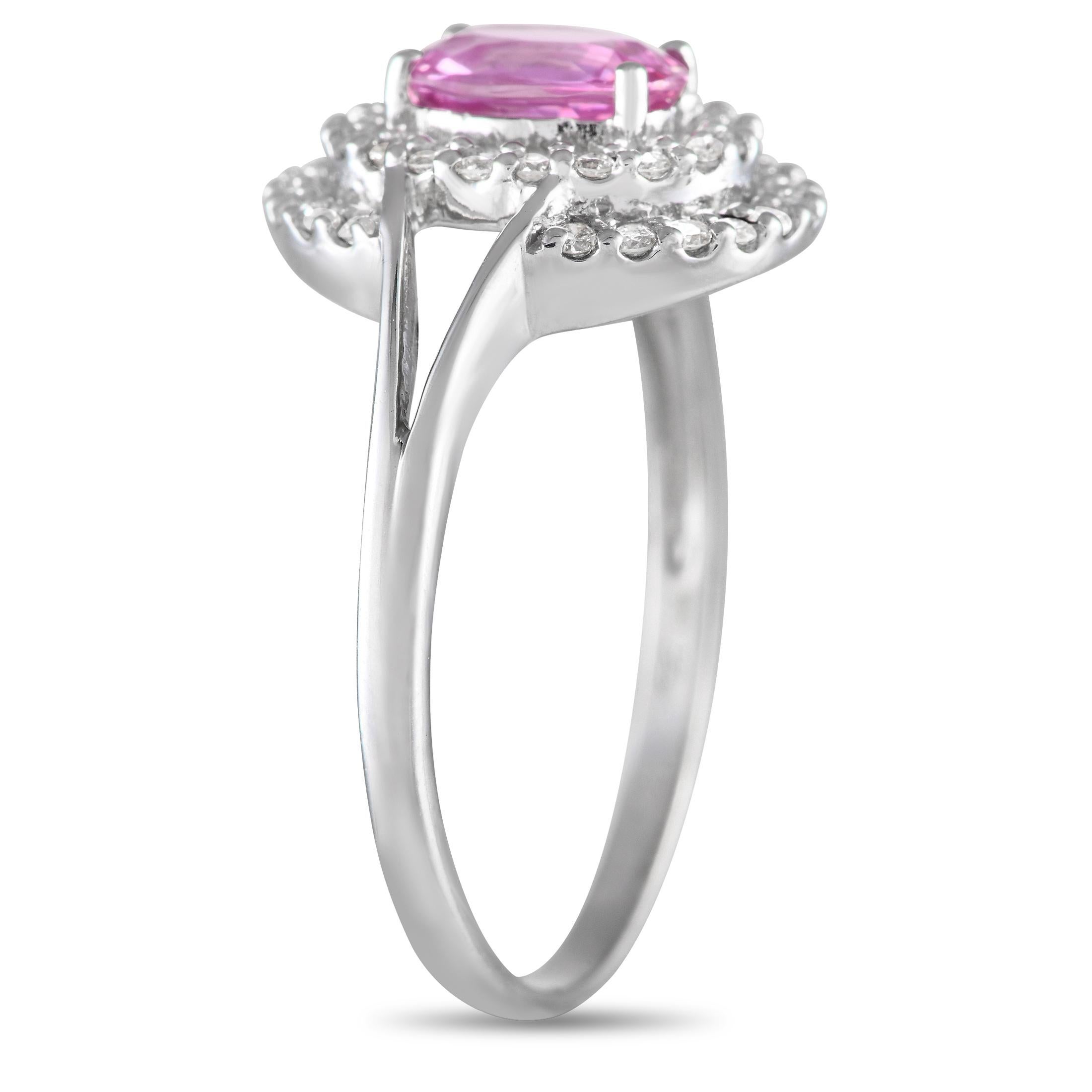 Sie wird die kühne, aber schlichte Ästhetik dieses Rings lieben. Das schlanke Weißgoldband hat geteilte Schultern, die zu einem Halo aus runden Diamanten führen, die einen bezaubernden rosa Saphir von 1,23 Karat einrahmen. Ein Paar Diamantbögen