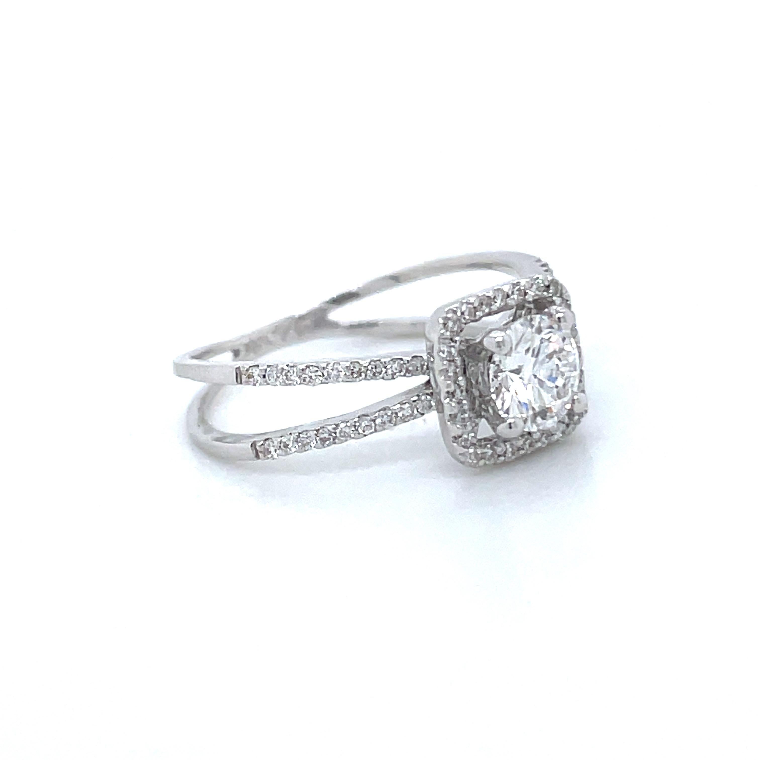 This 18k White Gold Round Brilliant Halo Engagement Ring whispers 