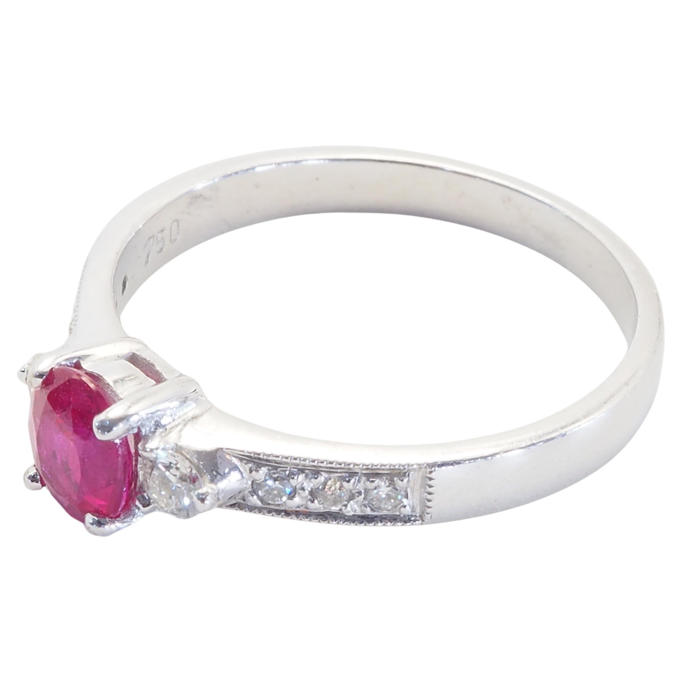 Este maravilloso anillo de compromiso ostenta un impresionante rubí rojo brillante de talla oval. El impresionante rubí de talla oval es refractivo y está engastado en medio de diamantes brillantes de talla redonda de buena ley. Es un rubí muy