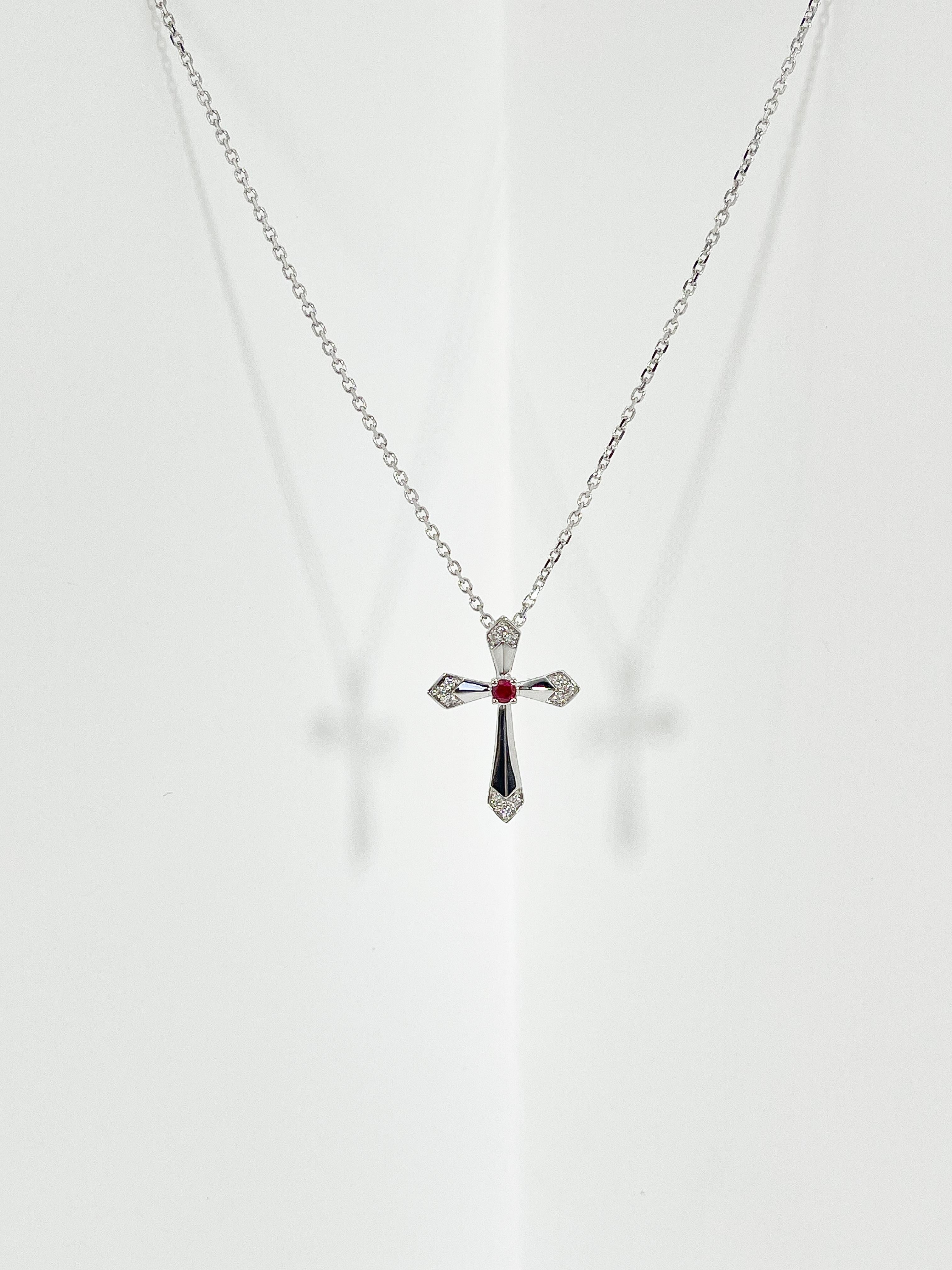 18k white gold .06 CTW diamond and .07 CT ruby cross necklace. All stones in this necklace are round, has a lobster clasp to open and close, the length of the necklace is 18 inches, the cross measures 21 x 15.5 mm, and it has a total weight of 3.4