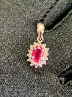 Pendentif en or blanc 18 carats avec un rubis ovale de 0,61 ct et un halo de diamants de 0,18 ct