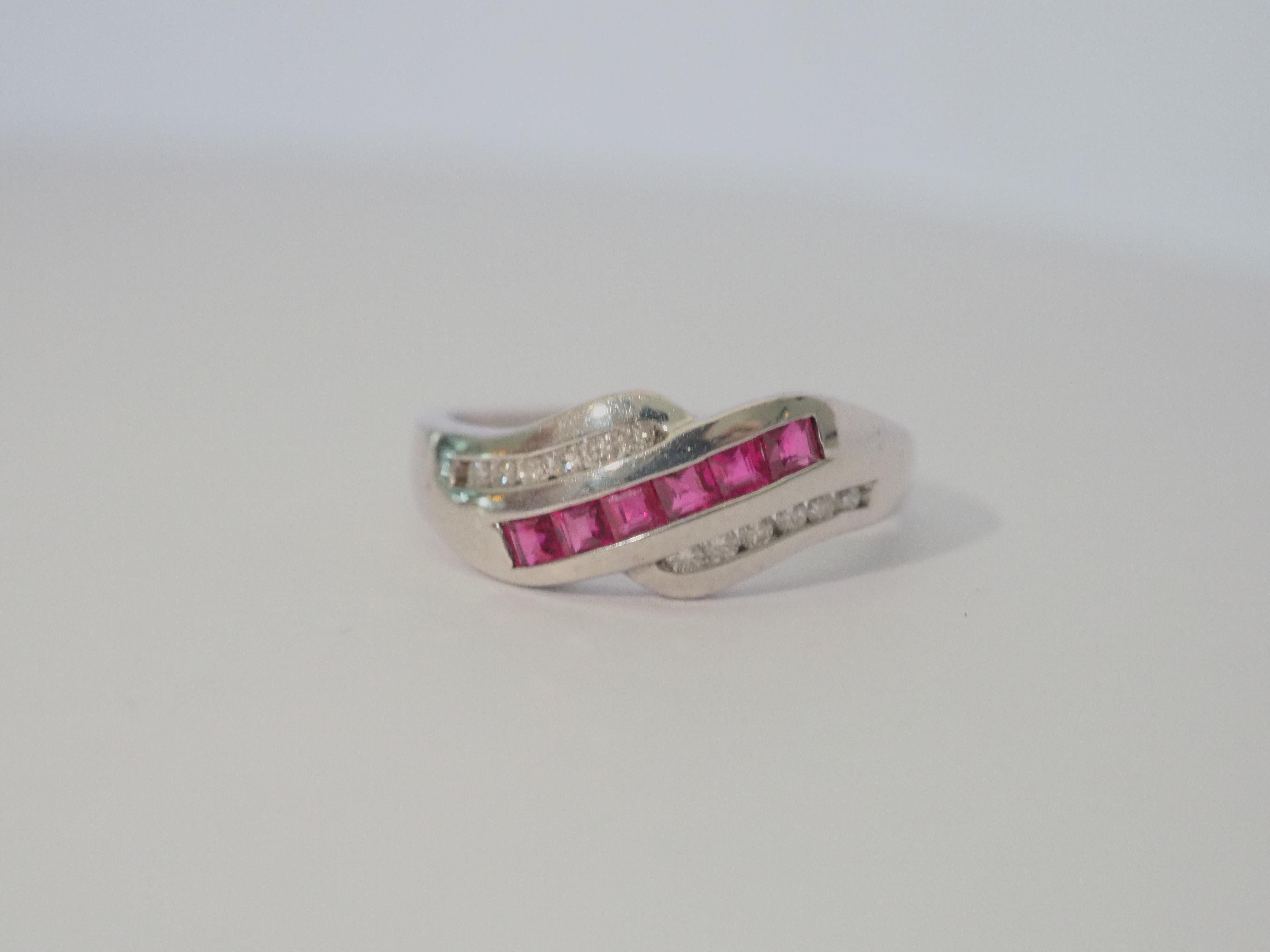 A gorgeous luxury wavy band ring that is both suitable for all sexes. This ring has a total of 6 of beautiful Thai rubies and pave round diamonds channeled nicely into the band. The square cut rubies have a beautiful pinkish red hue. And the 12