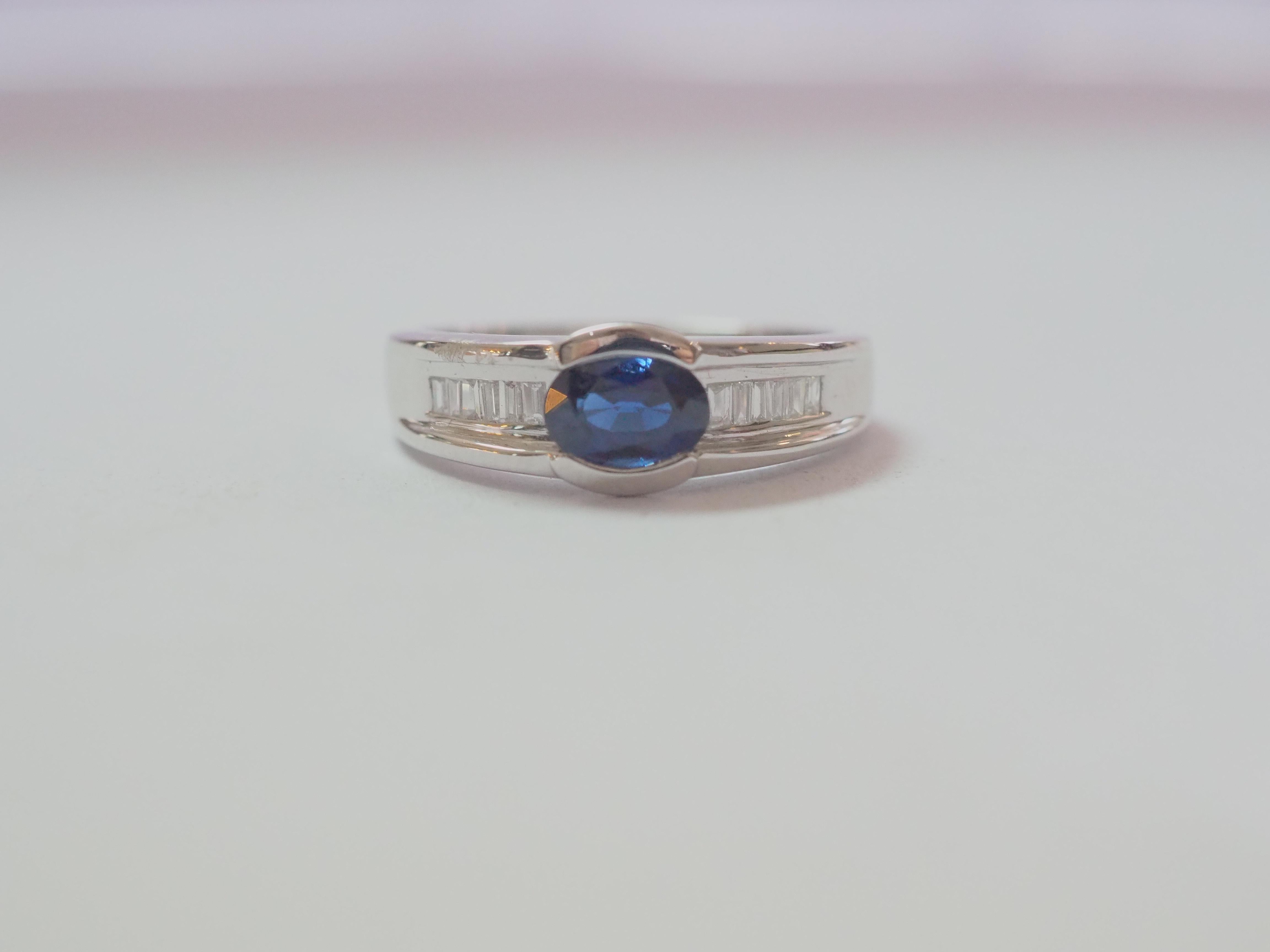 Auction Estimate:
$750-$2,000

This beautiful unisex band ring boasts a very stunning and eye clean blue sapphire! The sapphire is an east-meets-west oval cut and is very clear with dark tone of nice blue color. There are 12 baguette cut diamonds on