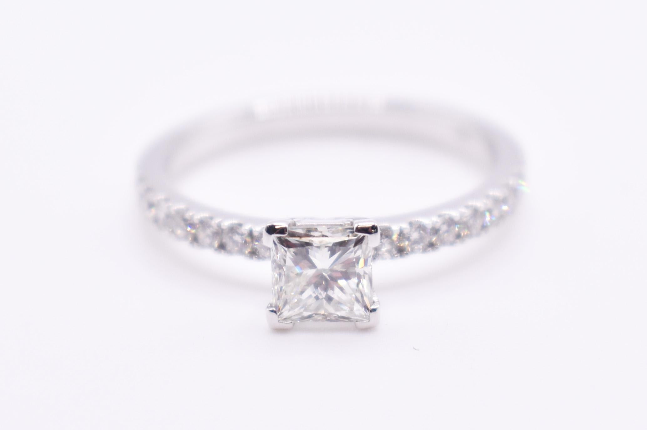 On offer for sale is a beautiful 18K white gold 0.74ct diamond engagement ring, having a princess cut diamond centre with pave sides. 

Metal: 18K White Gold
Total Carat Weight: 1.02
Colour: H
Clarity: VS2
Size: US= 7 UK=N