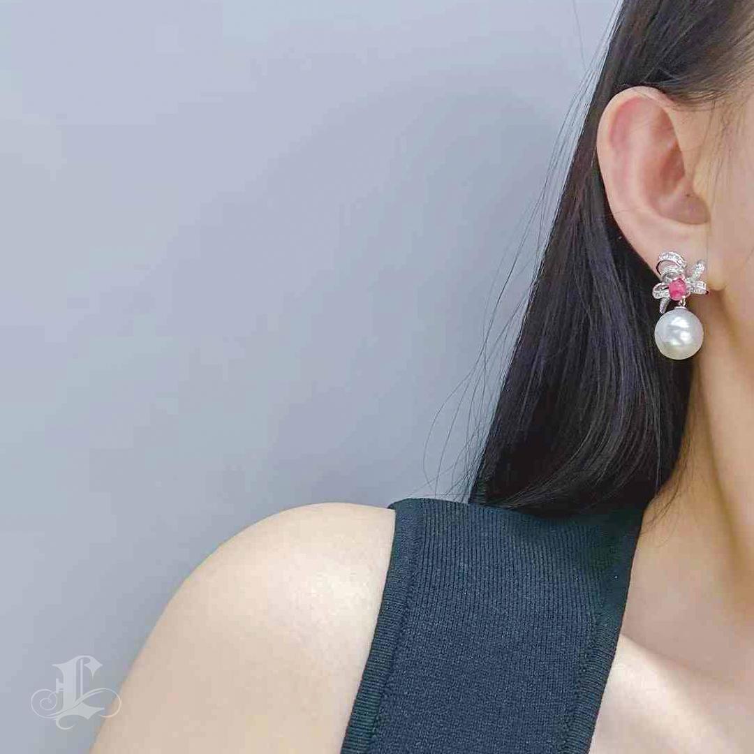 Whimsical yet refined, these earrings bring together the rare allure of flamingo pink conch pearls and the luminous elegance of 12–13mm AAAA South Sea pearls. Each piece features a bow-shaped flourish of 0.85ct of natural diamonds, from which the