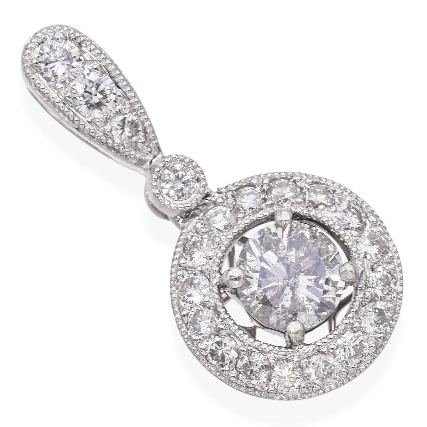 Ce pendentif est réalisé en or blanc 18k et présente un éblouissant 0,91tcw de diamants. En son centre se trouve un diamant taillé en brillant, encadré par un halo étincelant qui rehausse son feu et sa présence. La monture en or blanc ajoute une