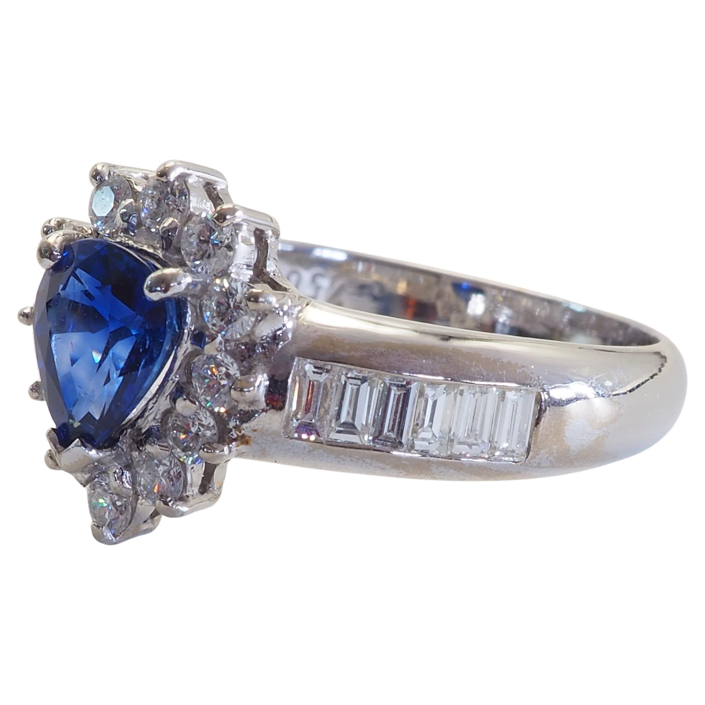 Este hermoso anillo de banda fina ostenta un zafiro azul talla pera de asombrosa belleza! muy hermoso. Un zafiro azul casi real, pero con una saturación decente de azul y fuego. La gema azul está rodeada de diamantes brillantes de tamaño decente y
