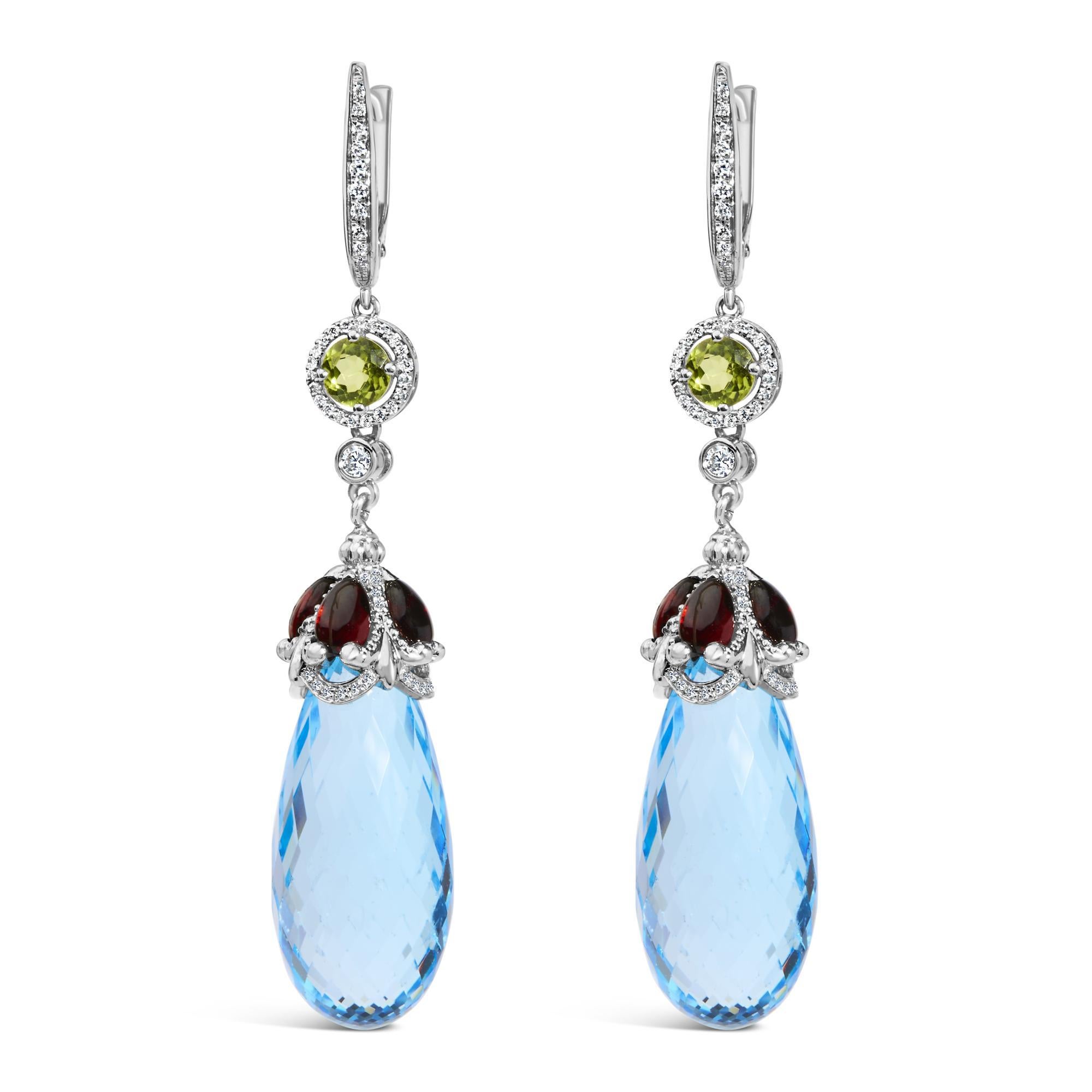Immerse yourself in the opulence of these exquisite 18K white gold earrings, where the brilliance of natural diamonds meets the mystical allure of color-treated blue topaz and red garnet. Each earring gracefully dangles at a length of 2 4/5 inches,