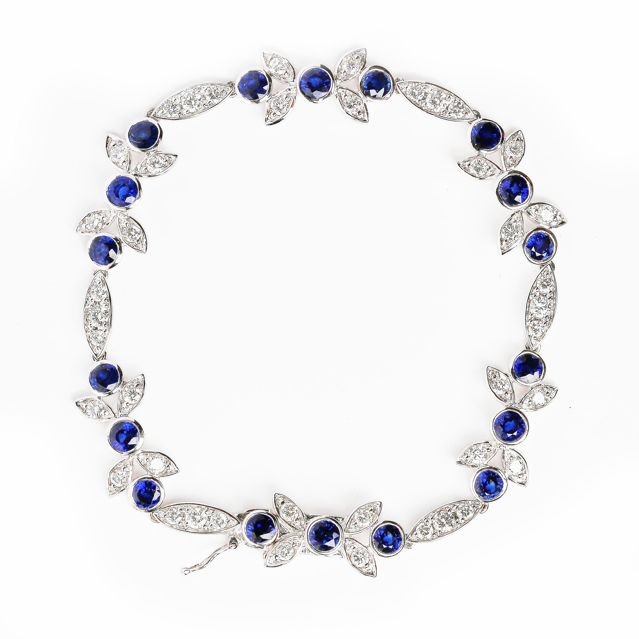 Made from a beautiful arrangement of horizontal marquise and floral shaped links, this 18k white gold bracelet graces the wrist in timeless elegance. This link bracelet features 3x3mm round heat-treated blue sapphire gemstones secured within bezel