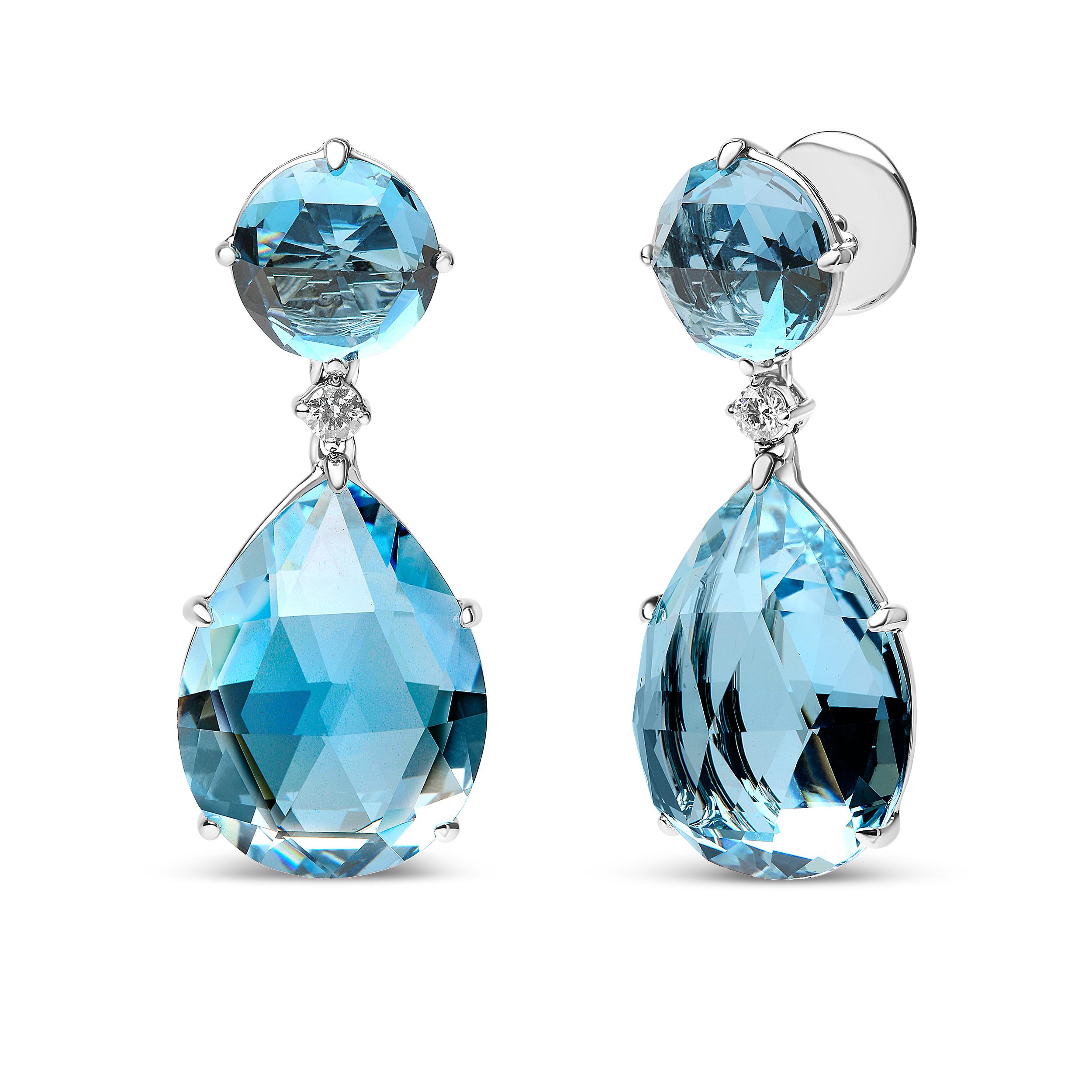 These attractive dangle earrings cultivate a sophisticated style in genuine 18k white gold with natural gemstones and diamonds in a linear design. The upper dangle shows off with a gleaming round color-treated London blue topaz gemstone in a prong