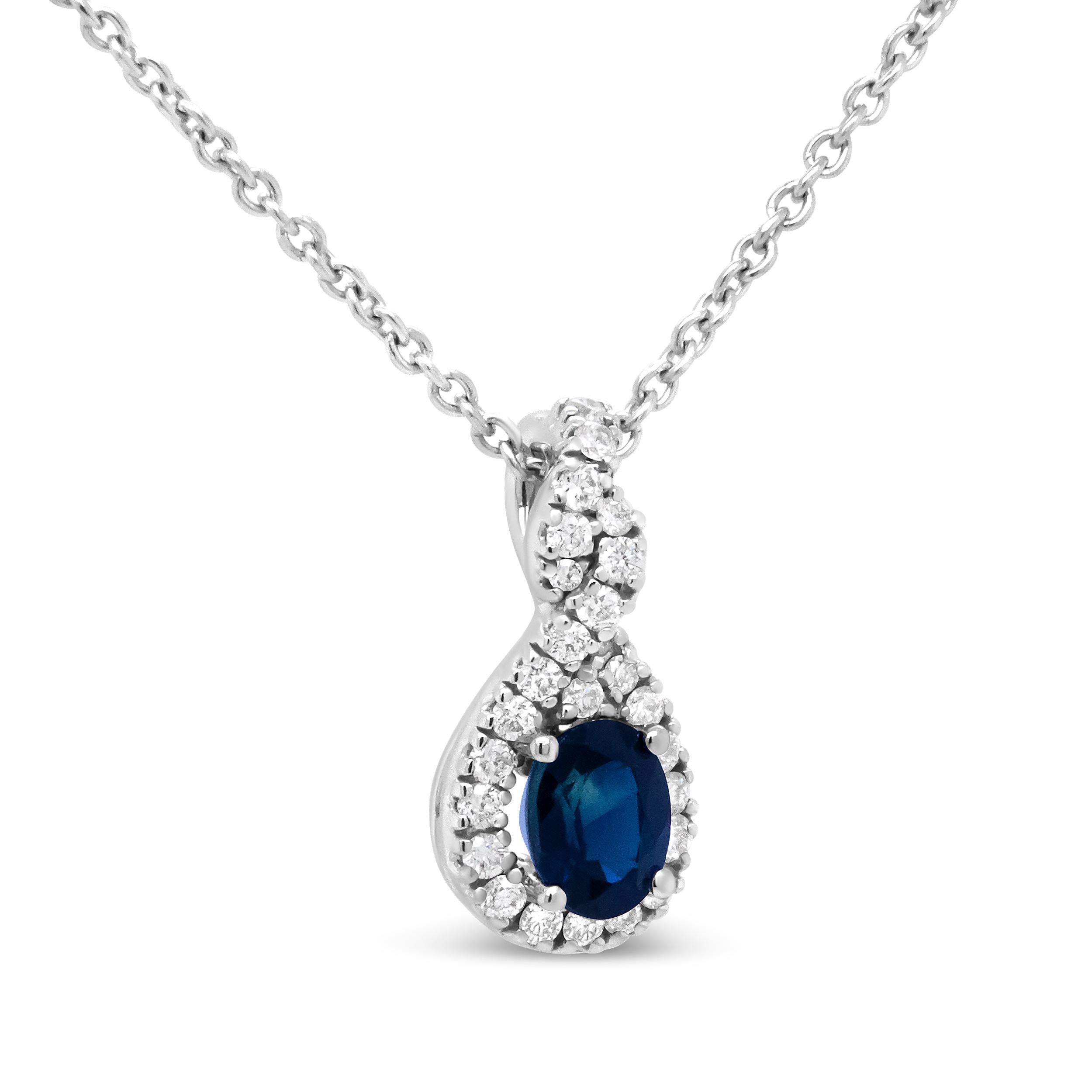 Exuding classic elegance, this exquisite blue sapphire pendant showcases a timeless drop design in 18k white gold surrounded by exquisite diamonds with a total 1/7 cttw and an approximate G-H Color and SI1-SI2 Clarity. The 4.5x3.5mm oval sapphire is