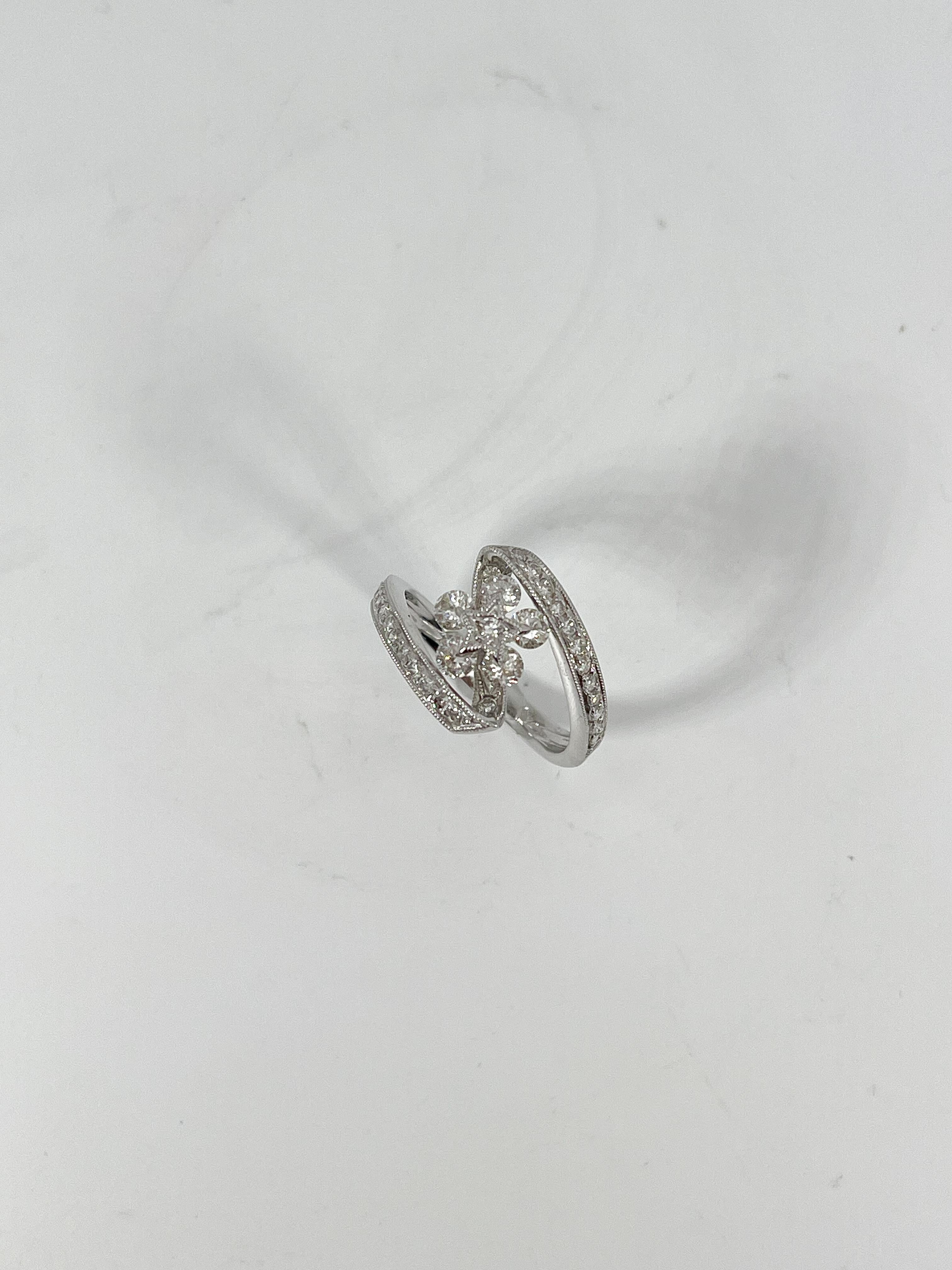 18k white gold 1 CTW diamond flower fashion ring. The stones in this ring are all round, ring is a size 6 1/2, the ring measures 13.3mm x 8mm, and has a total weight of 4.4 grams.