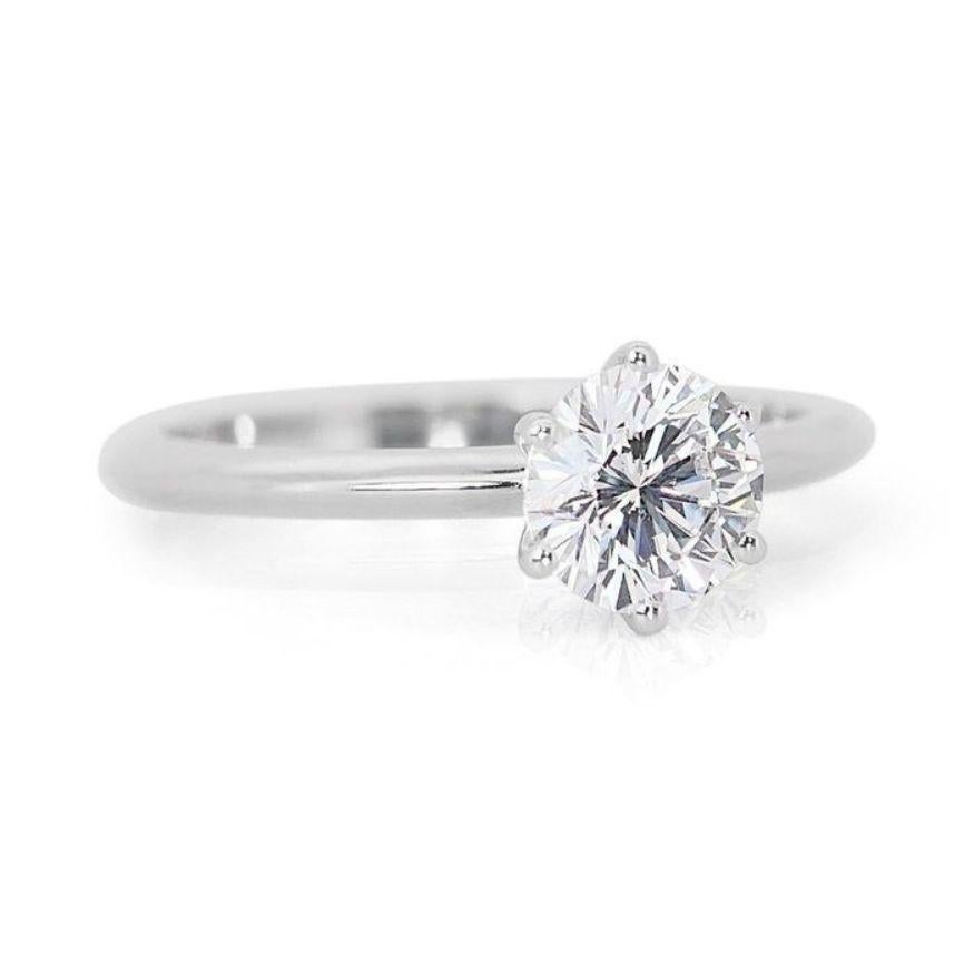 This ring is not merely an ornament; it's a conduit to pure light, a love letter whispered in every radiant facet. At its heart, nestled in 18K white gold, lies a magnificent 1.01-carat round brilliant diamond. This is no ordinary diamond—it's a